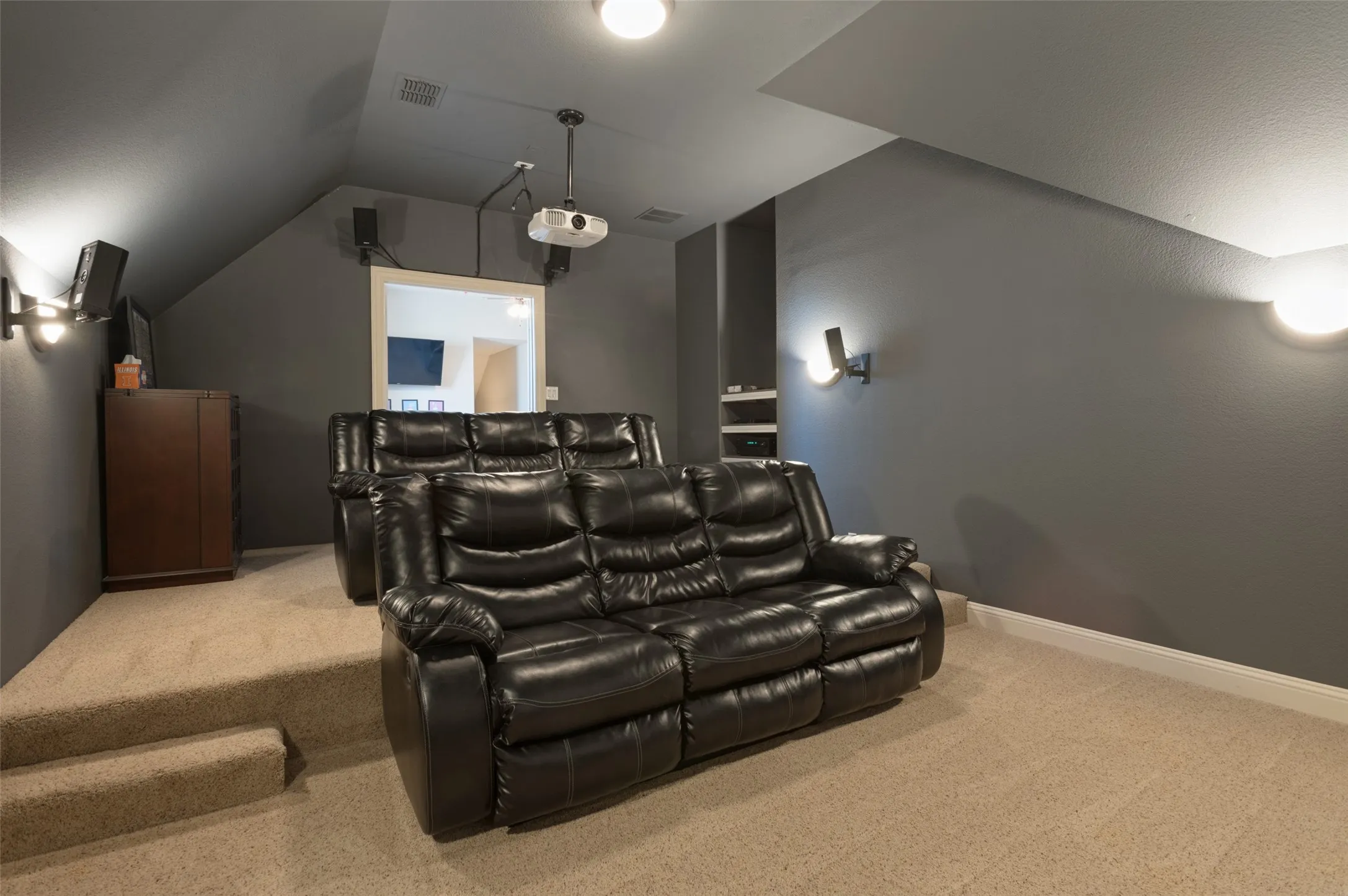 Dedicated media room with tiered carpeted flooring