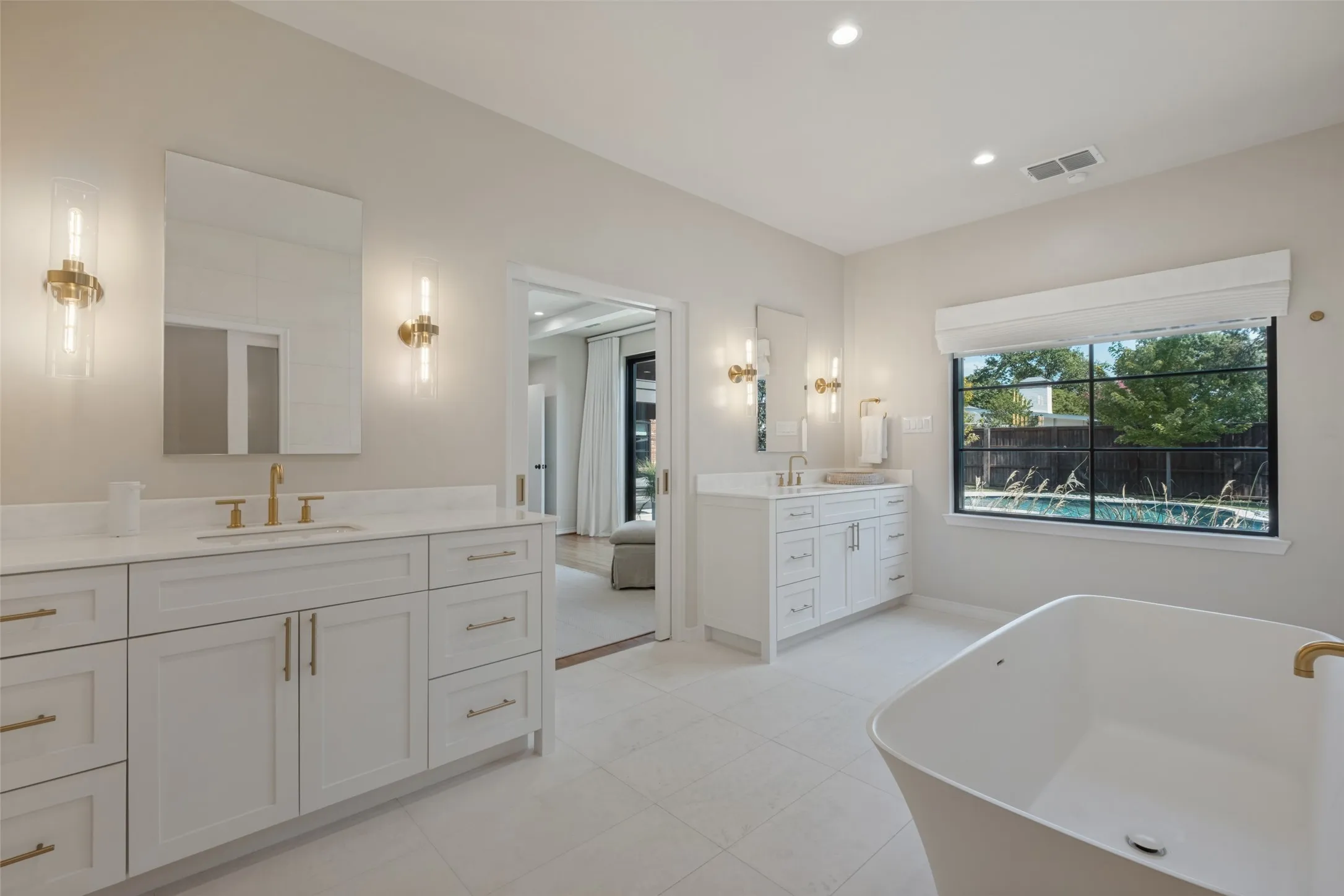 Spa like primary bathroom with separate vanities.