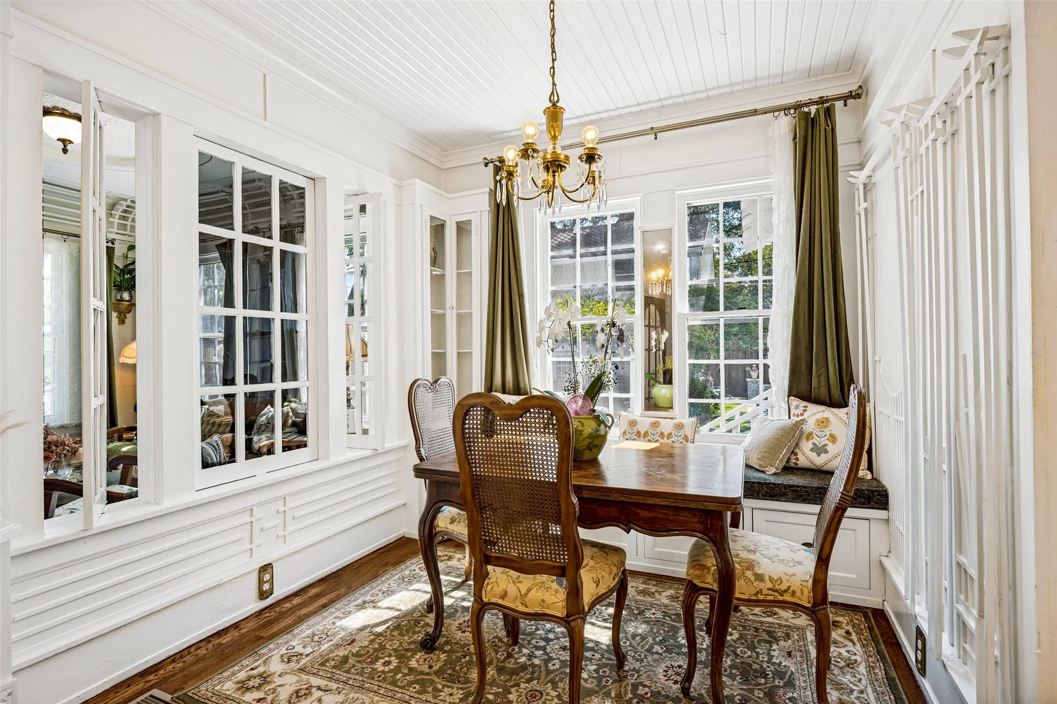 Wood-finish flooring, white paneled ceiling, and a built-in window bench
