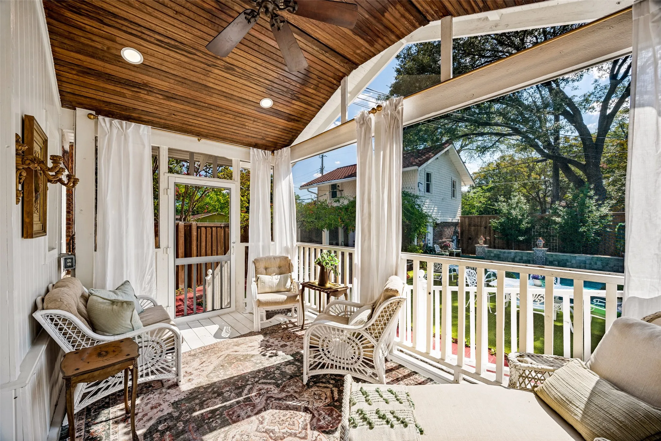 Screened porch with vaulted wood-plank ceiling, recessed lighting, and a ceiling fan