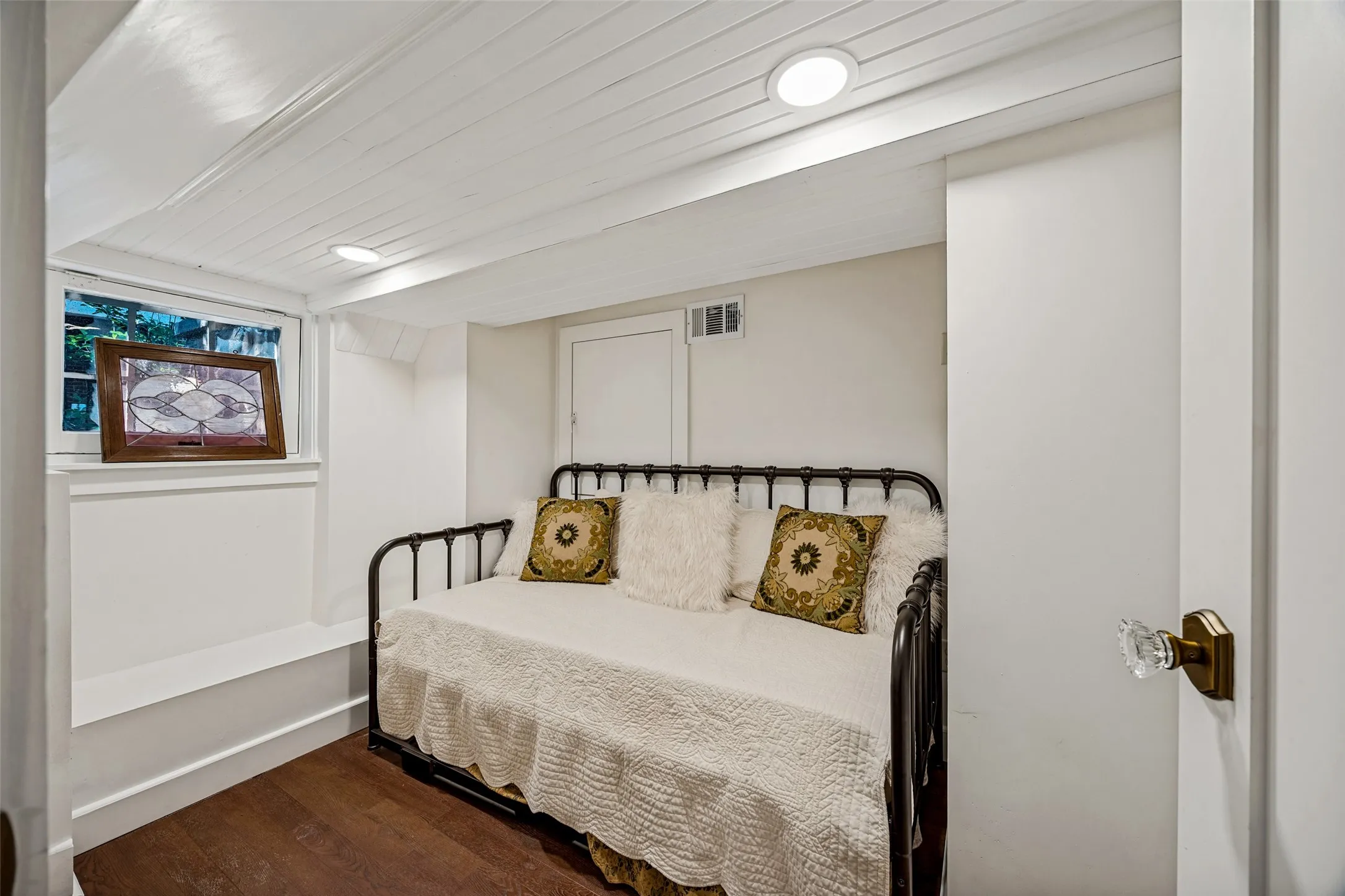 Wood-finish flooring with white baseboards, a white paneled ceiling with recessed lighting, and a white-painted window frame
