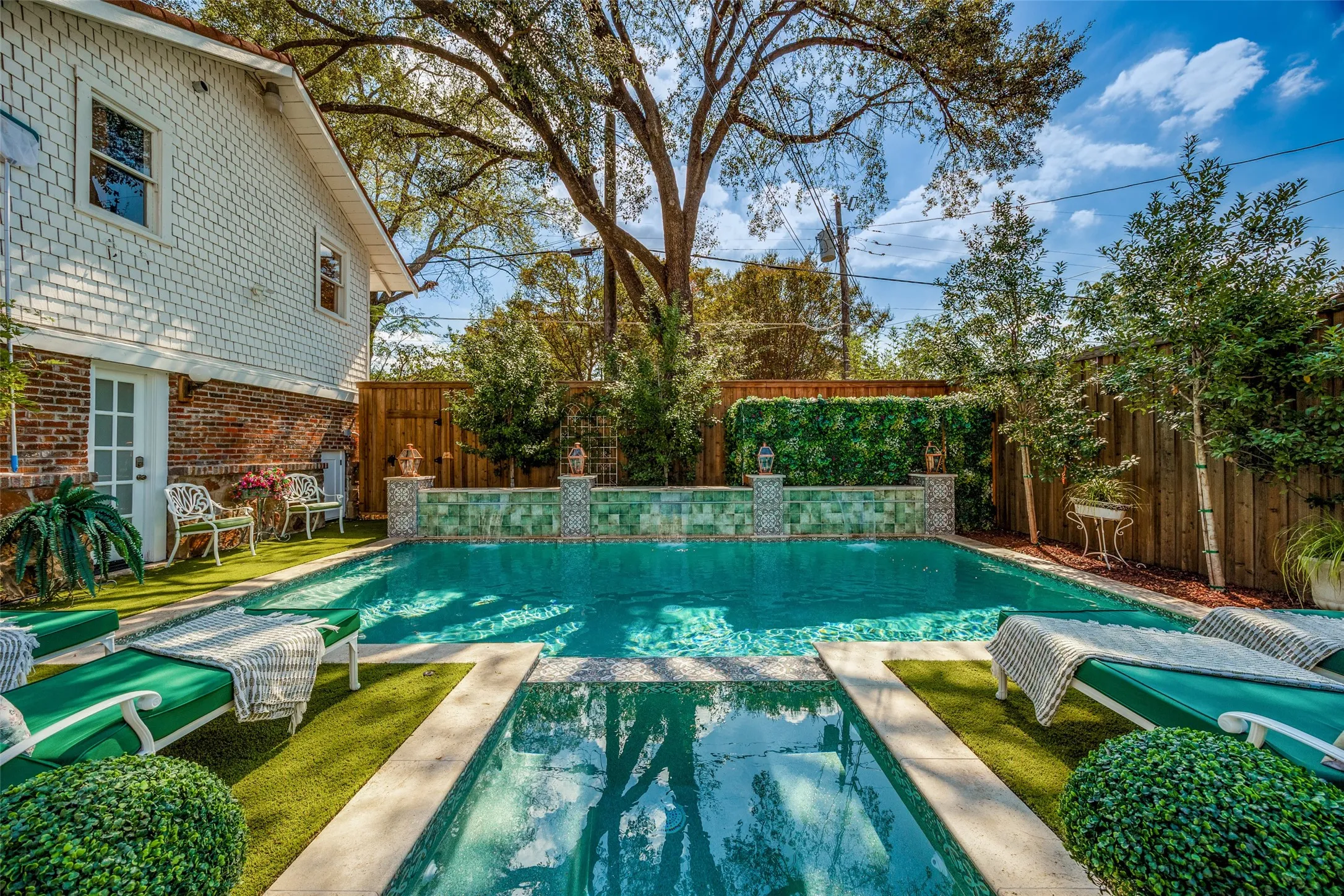 Shingle-sided exterior with brick foundation, French door access, rectangular swimming pool, and artificial turf surrounds