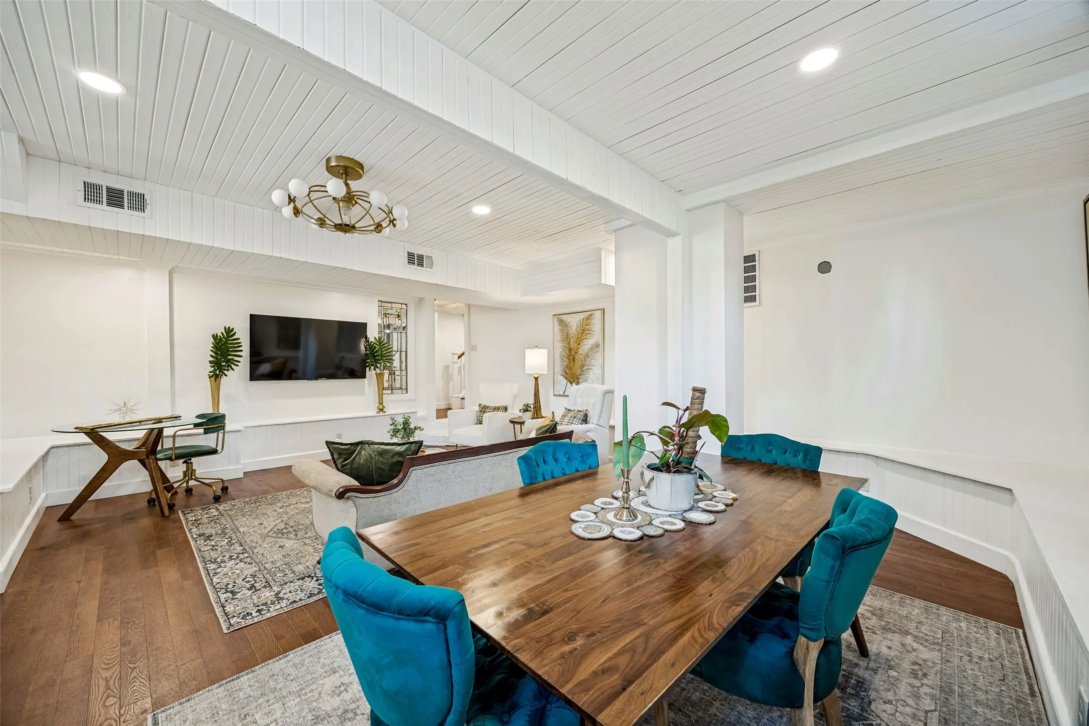 Open-concept living area featuring wood-finish flooring, a contemporary chandelier, recessed lighting, and white shiplap ceiling accents