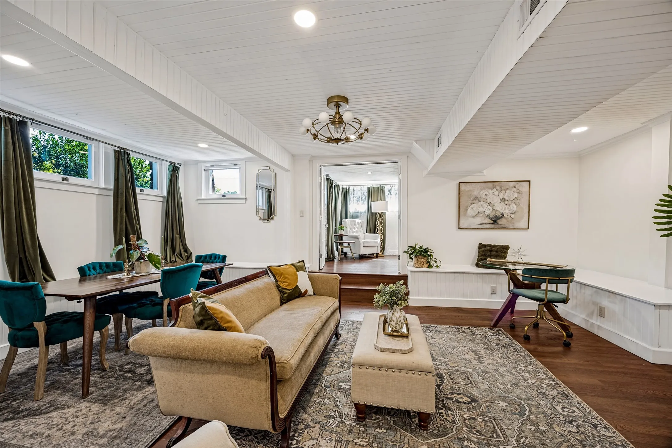 Wood-finish flooring throughout, featuring a recessed lighting, a built-in bench, and a decorative chandelier