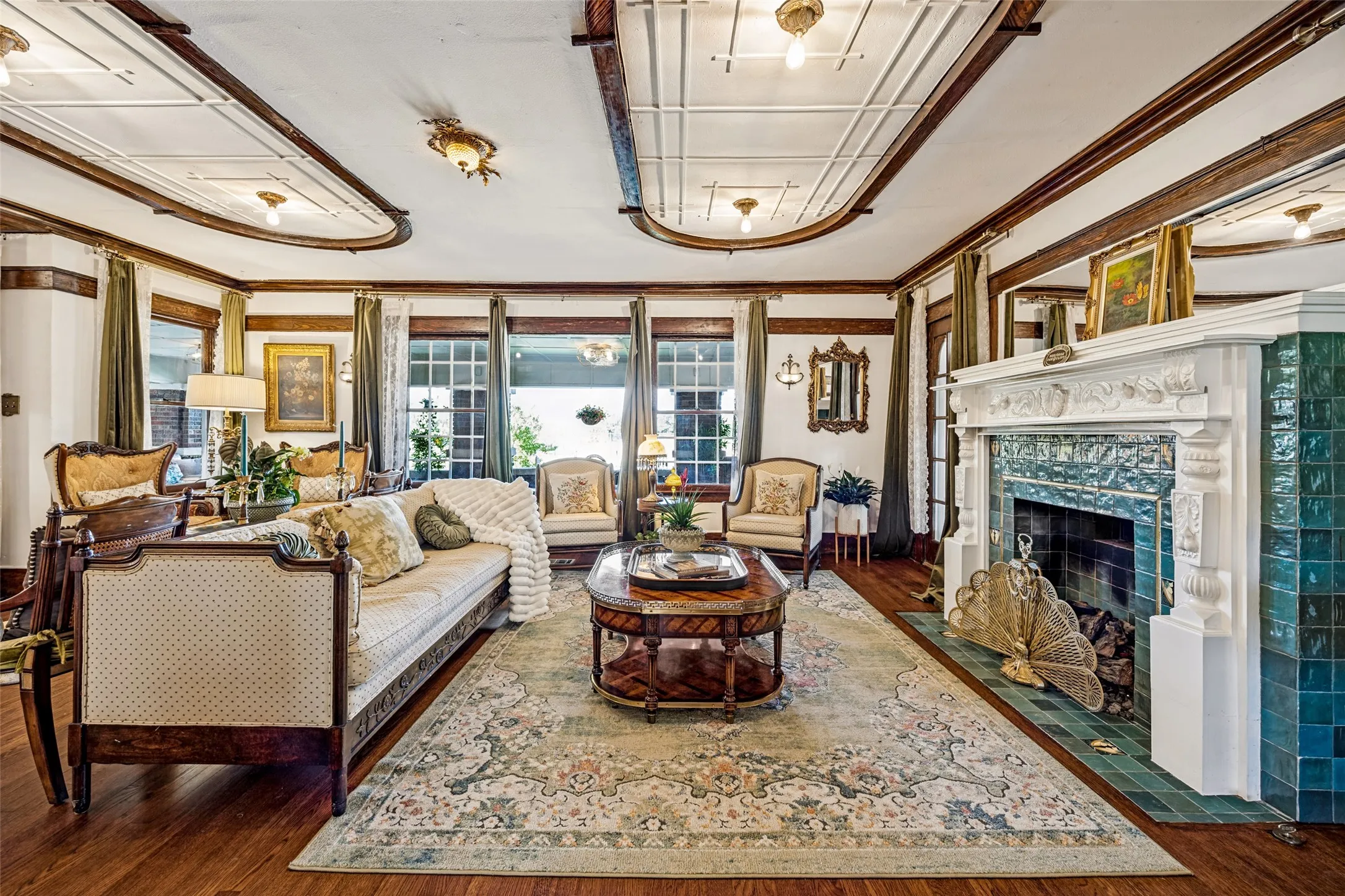 Hardwood flooring throughout, featuring a fireplace with teal tiled surround and white mantel