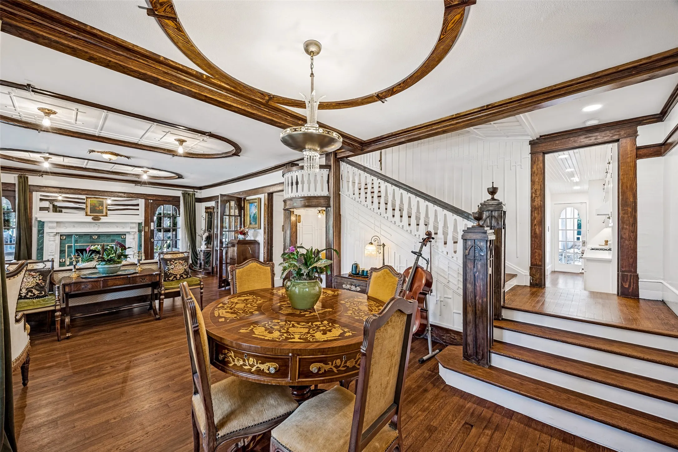 Hardwood flooring, ornate ceiling details, built-in fireplace, detailed wood staircase, and custom millwork throughout