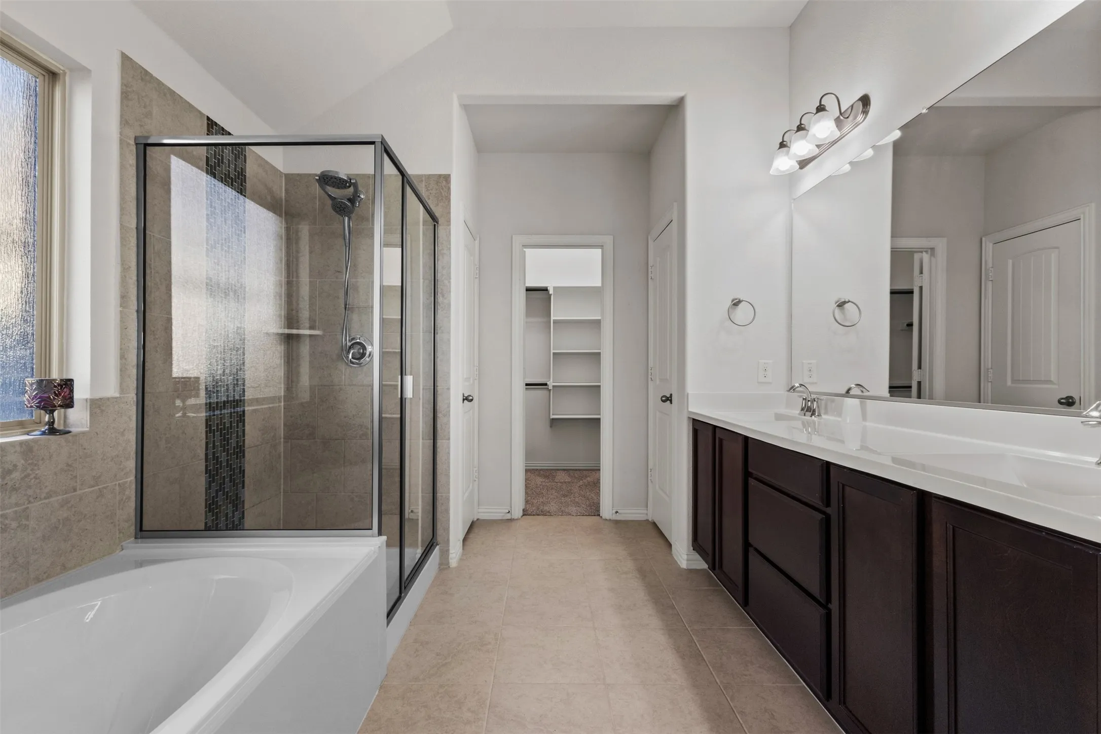 Dual vanity with white countertops, dark wood-finish cabinetry, and framed mirror