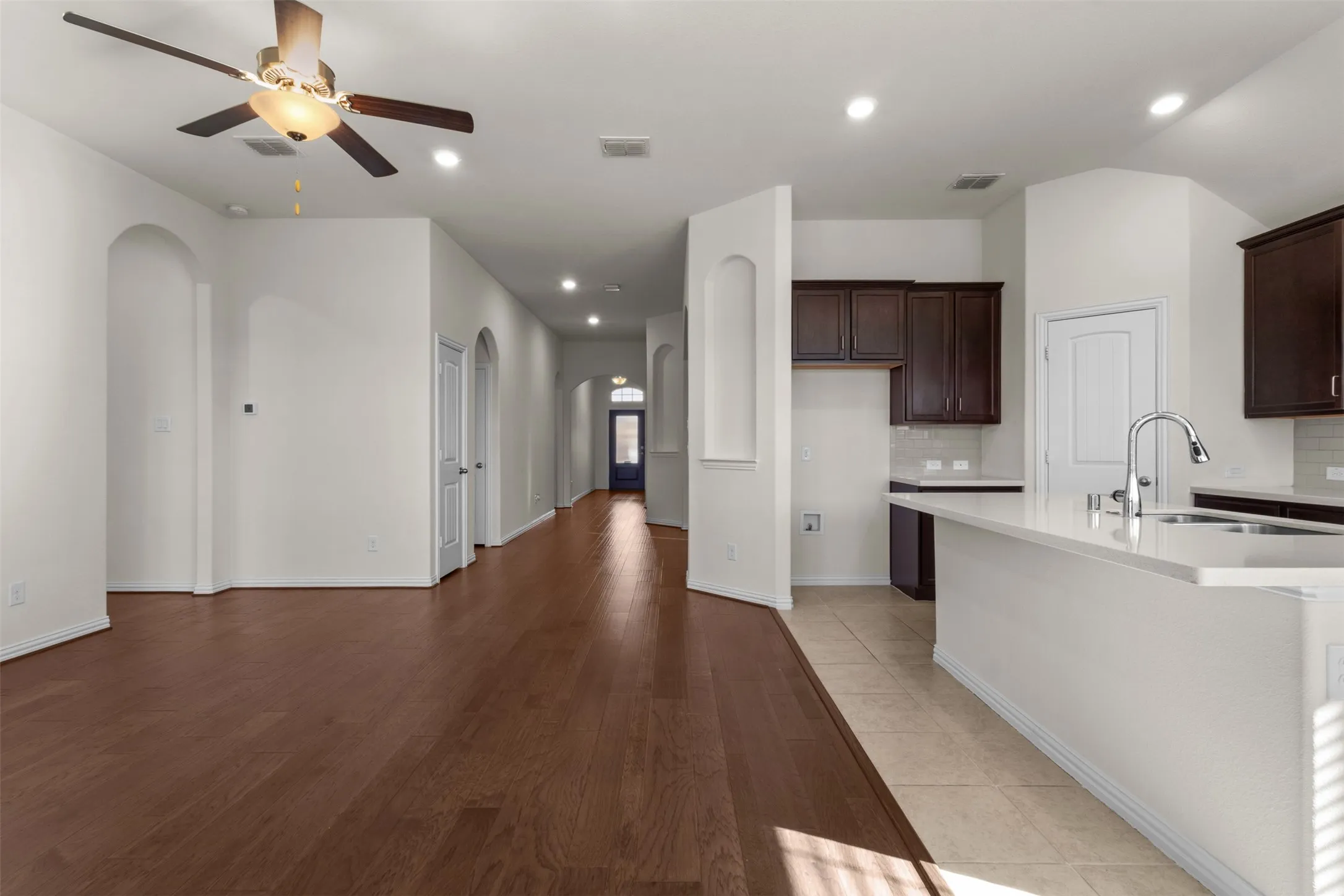 Expansive living space featuring wood-finish flooring, recessed lighting, and a ceiling fan