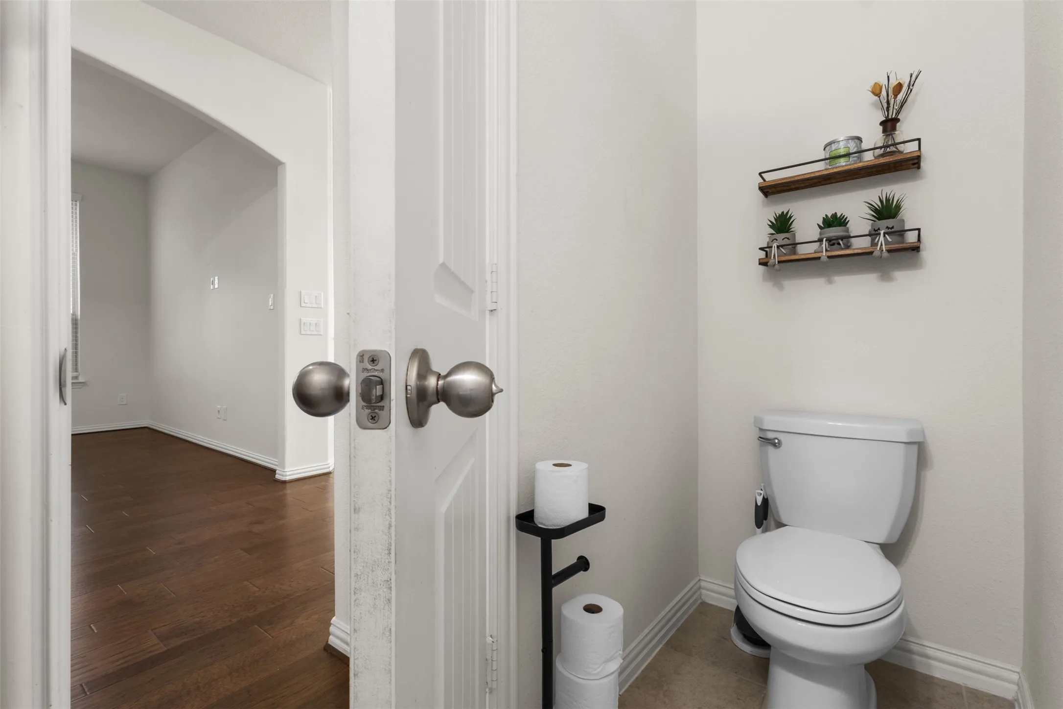 Powder room featuring a white toilet, neutral wall paint, and ceramic tile flooring