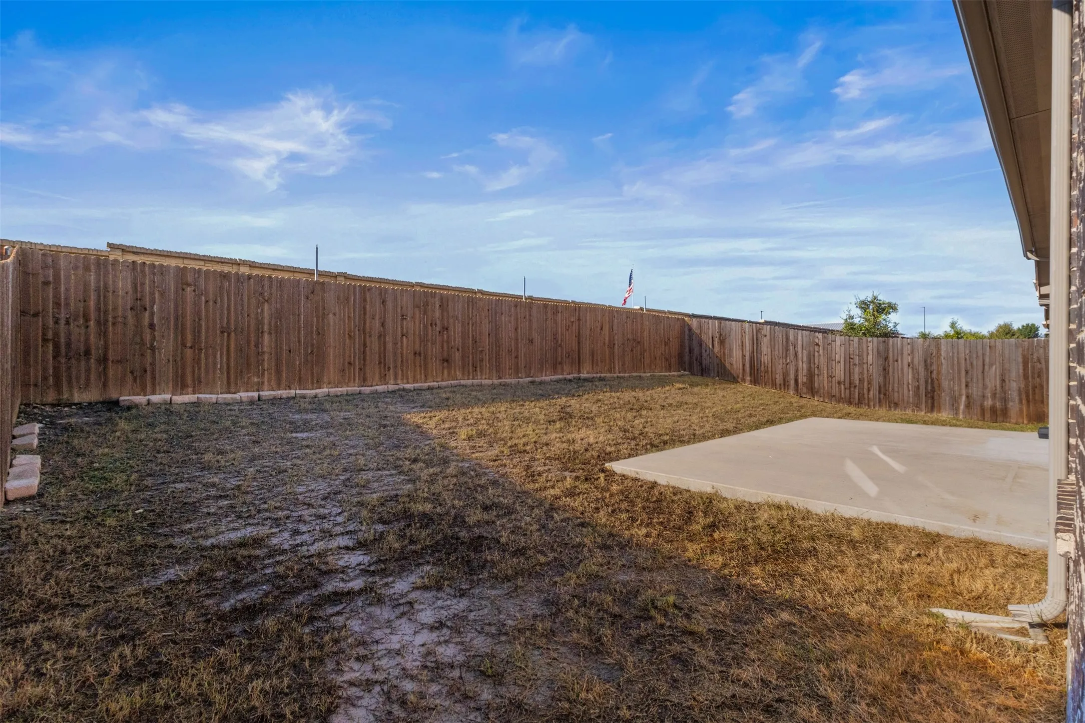 Fenced backyard with a concrete patio