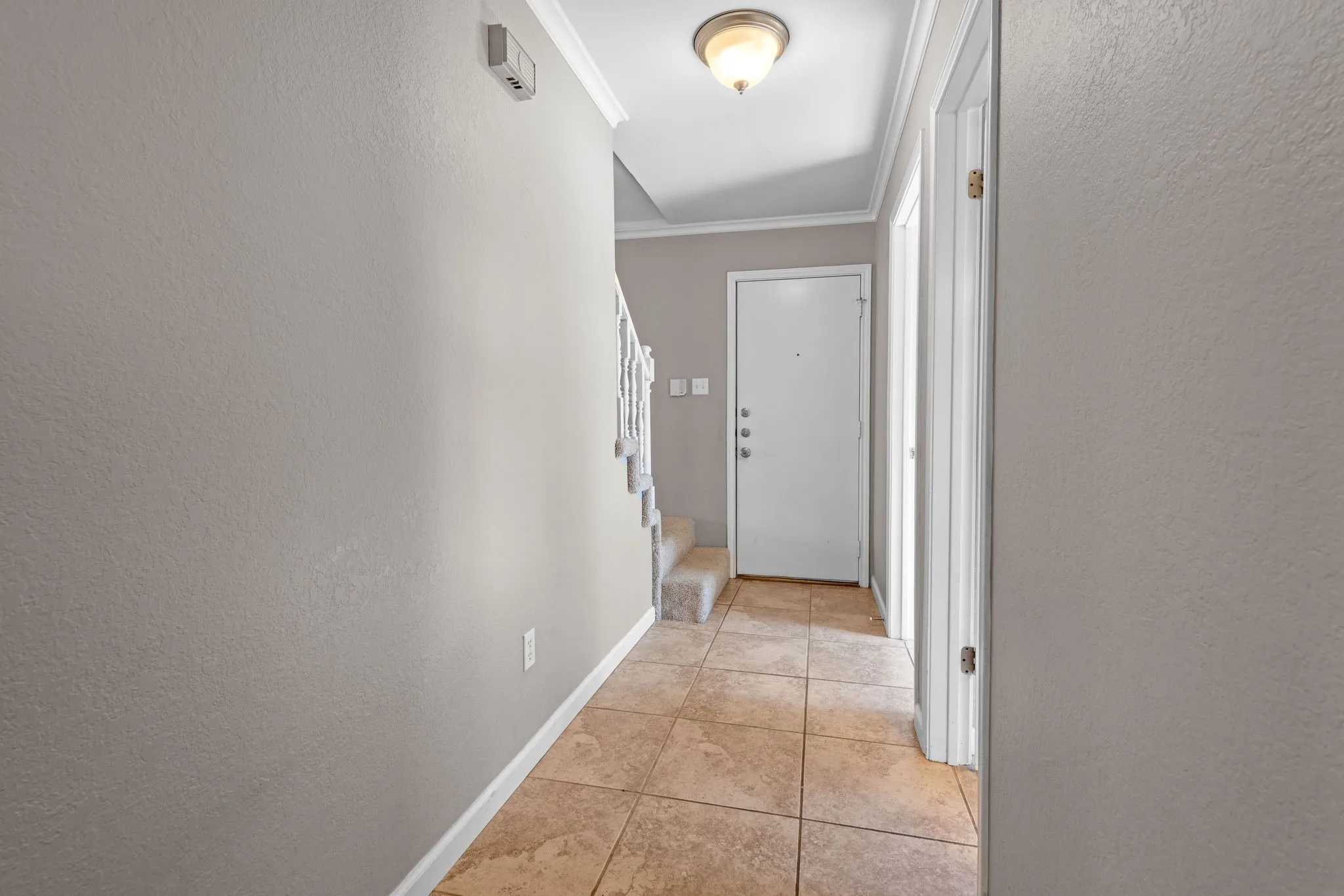 Hallway that leads to landing up to the upper level, garage, laundry, and half bath.