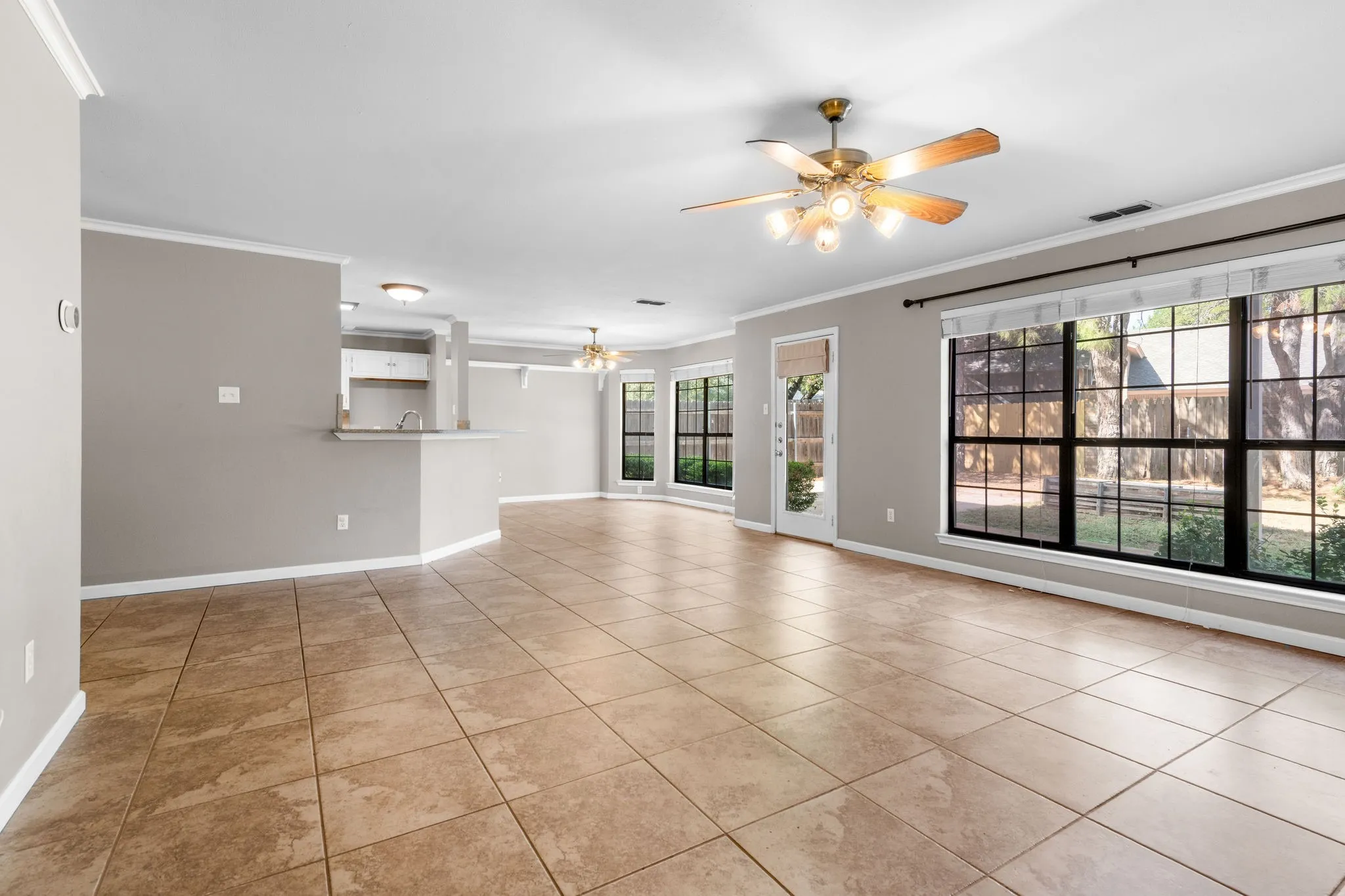 Living room with view of private back yard from living and breakfast area windows.  Wrap around bar with granite top.