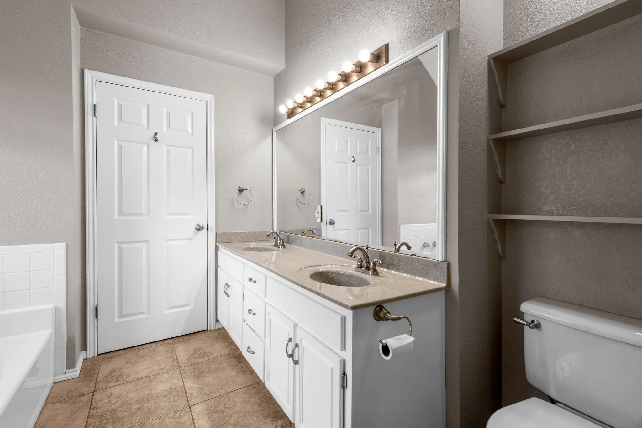 Primary bathroom with walk in closet, garden tub, and double sinks.