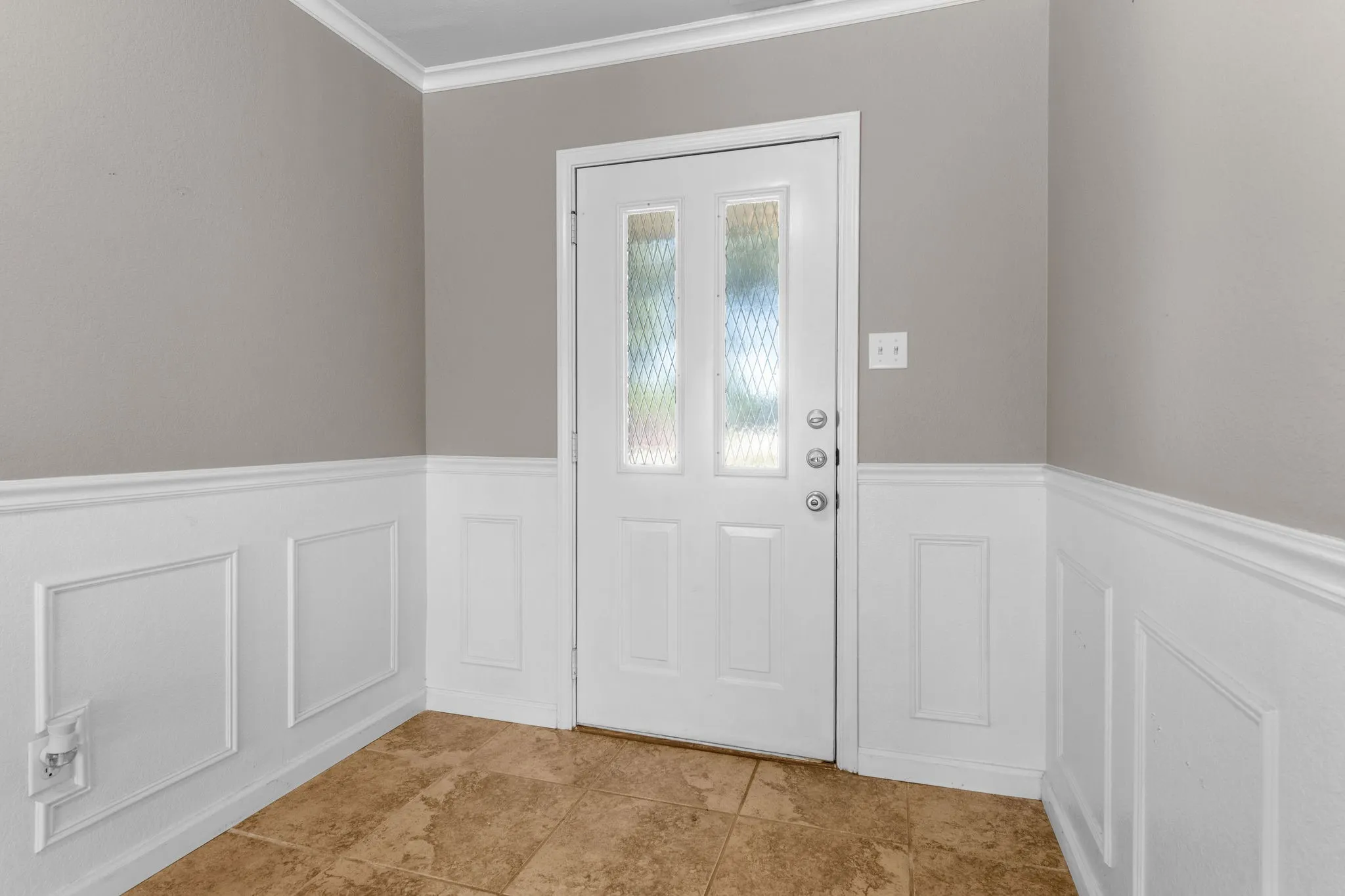 Foyer is enhanced with wainscoting panels and large 18" tile flooring.
