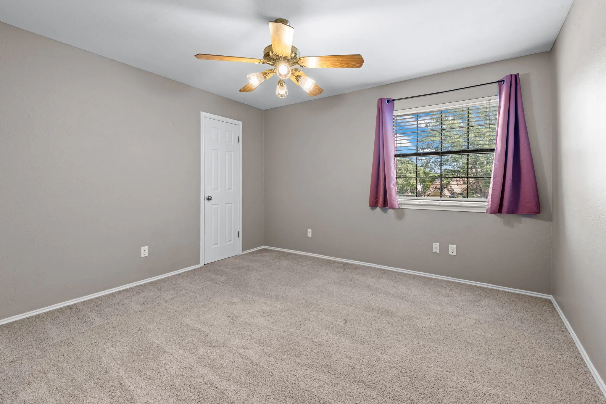 Middle upstairs bedroom with ceiling fan and closet plus a single window.