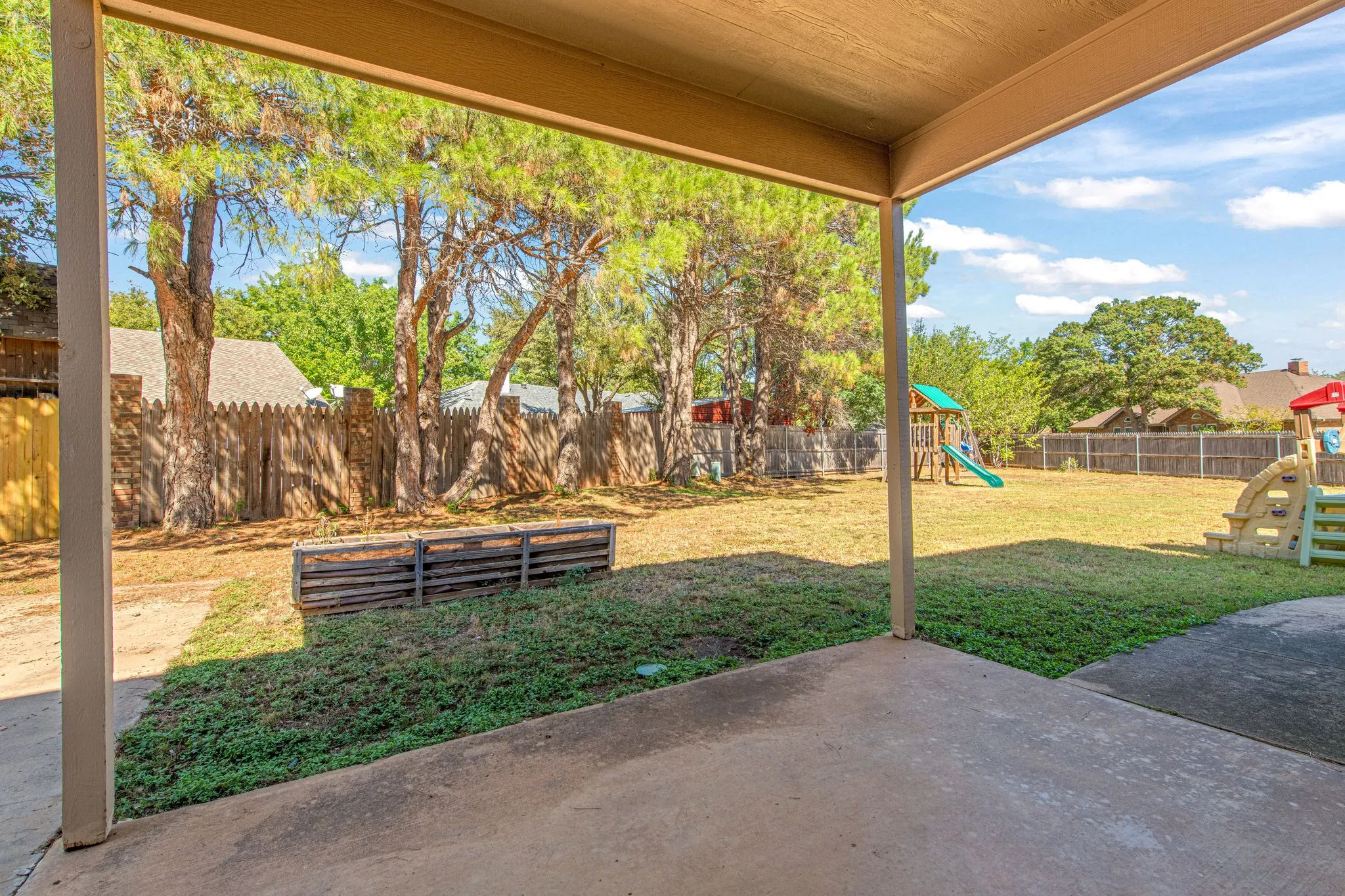 Backyard offers a covered patio, mature trees and space for endless activities!