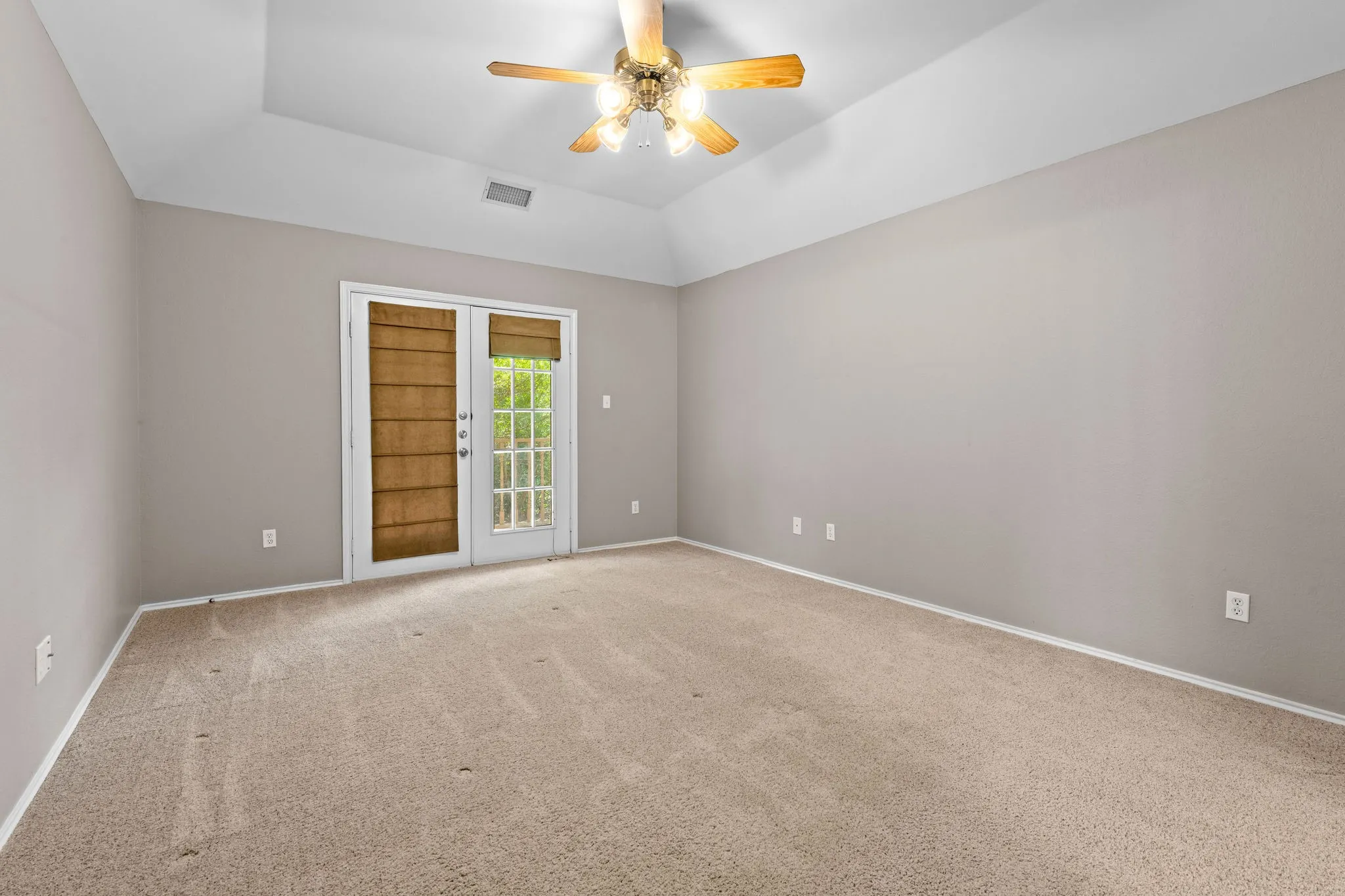 Primary bedroom with double doors that open to private balcony.