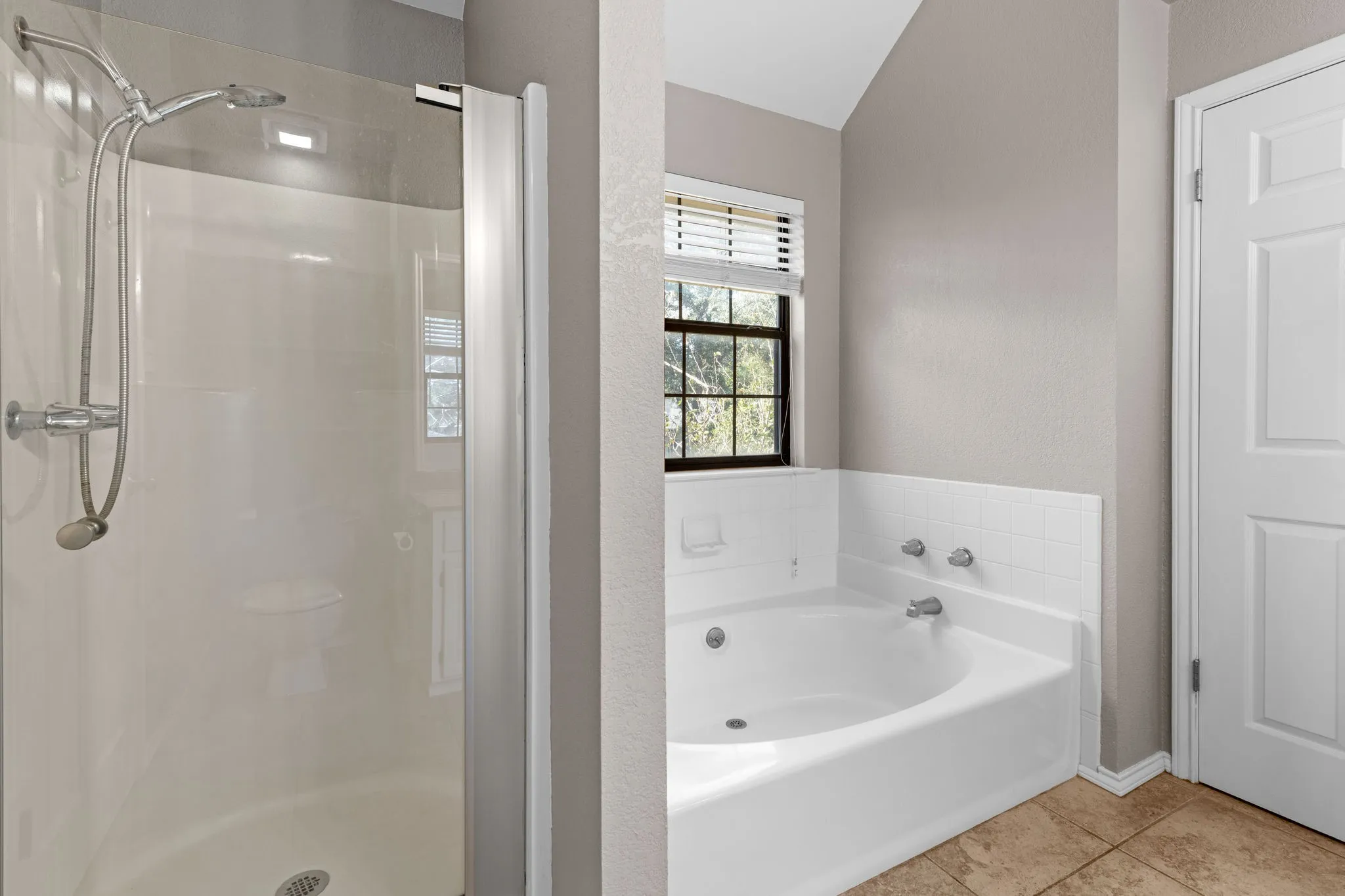 Primary bathroom with separate garden tub and walk in shower.
