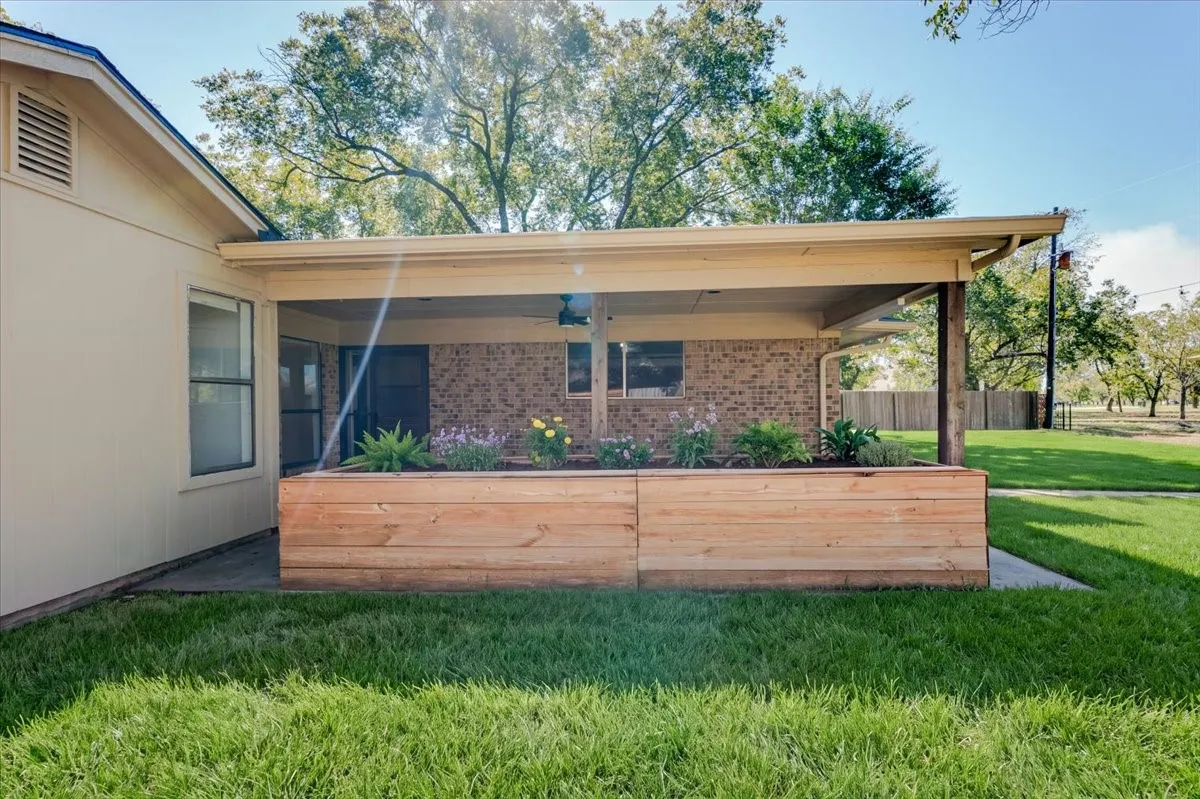 Backyard with raised flower bed. Picture altered to virtually stage flowers.