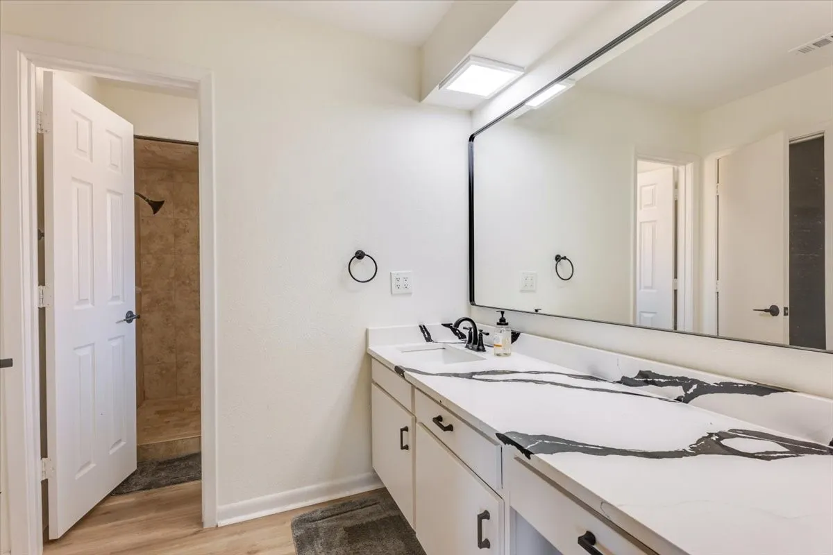 Double vanity with integrated sinks, black-veined countertop, and black hardware