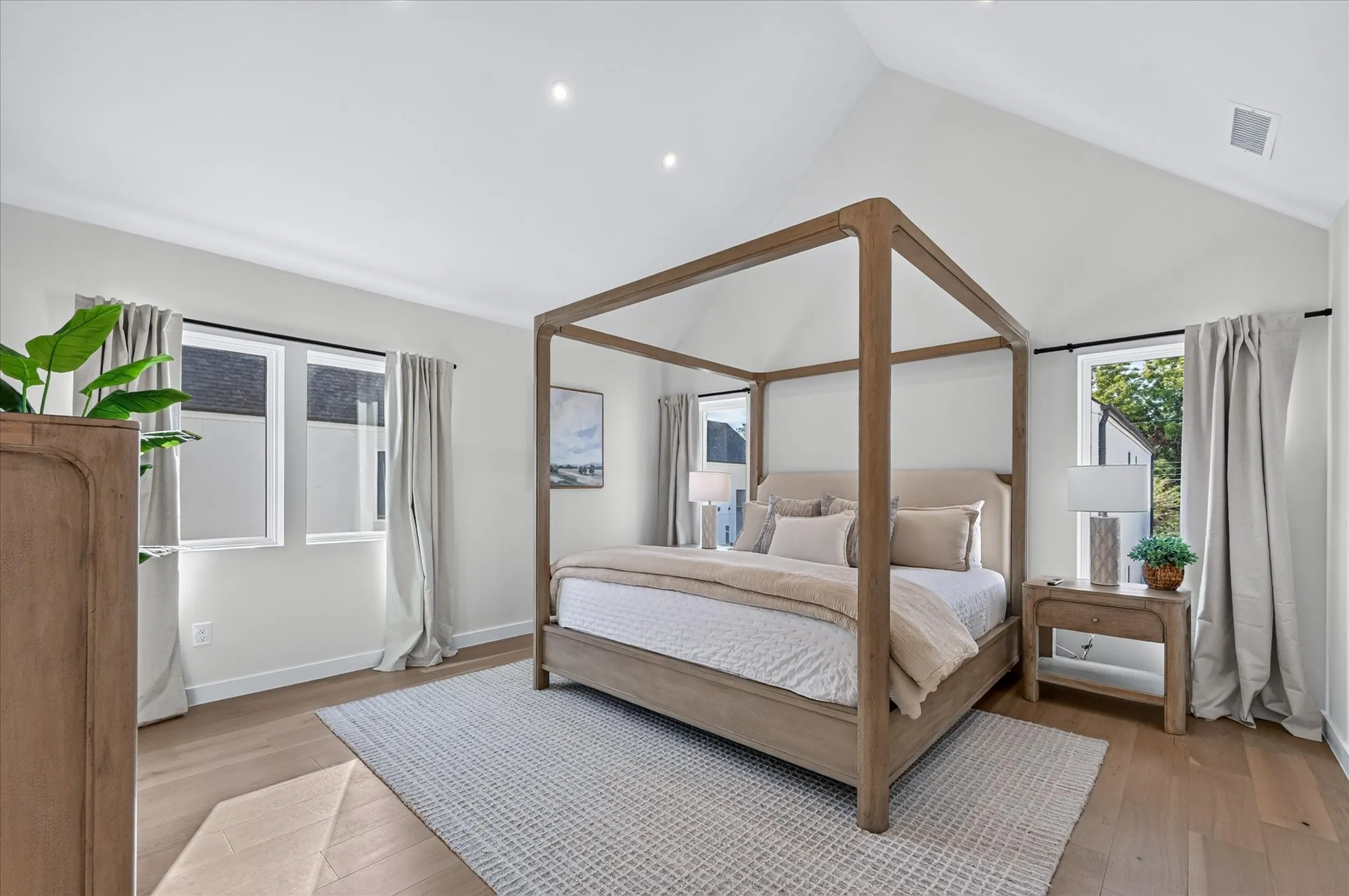 Vaulted ceiling, recessed lighting, wood-finish flooring, multiple windows, neutral wall tones
