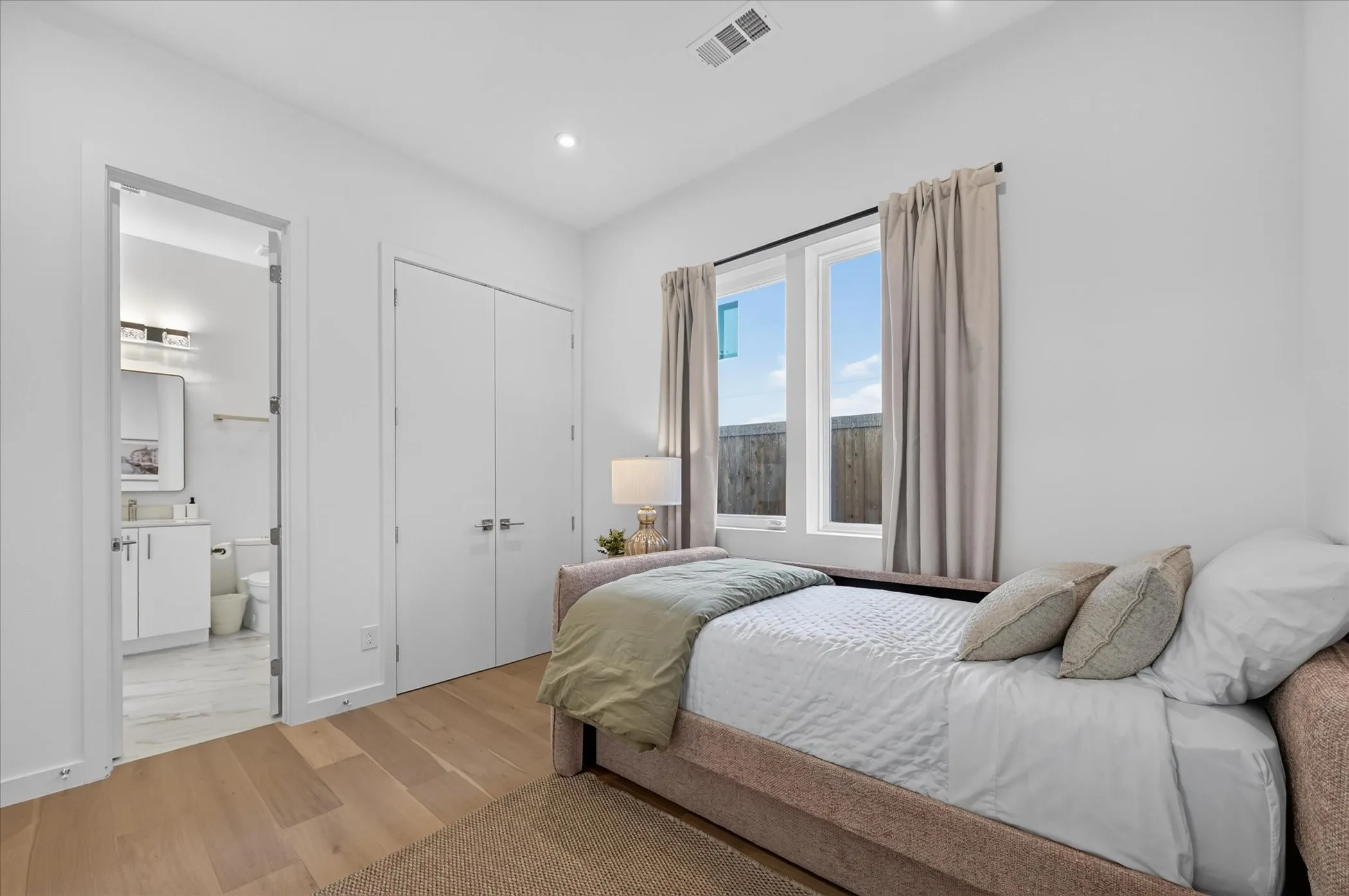 Recessed lighting, wood-finish flooring, and white walls