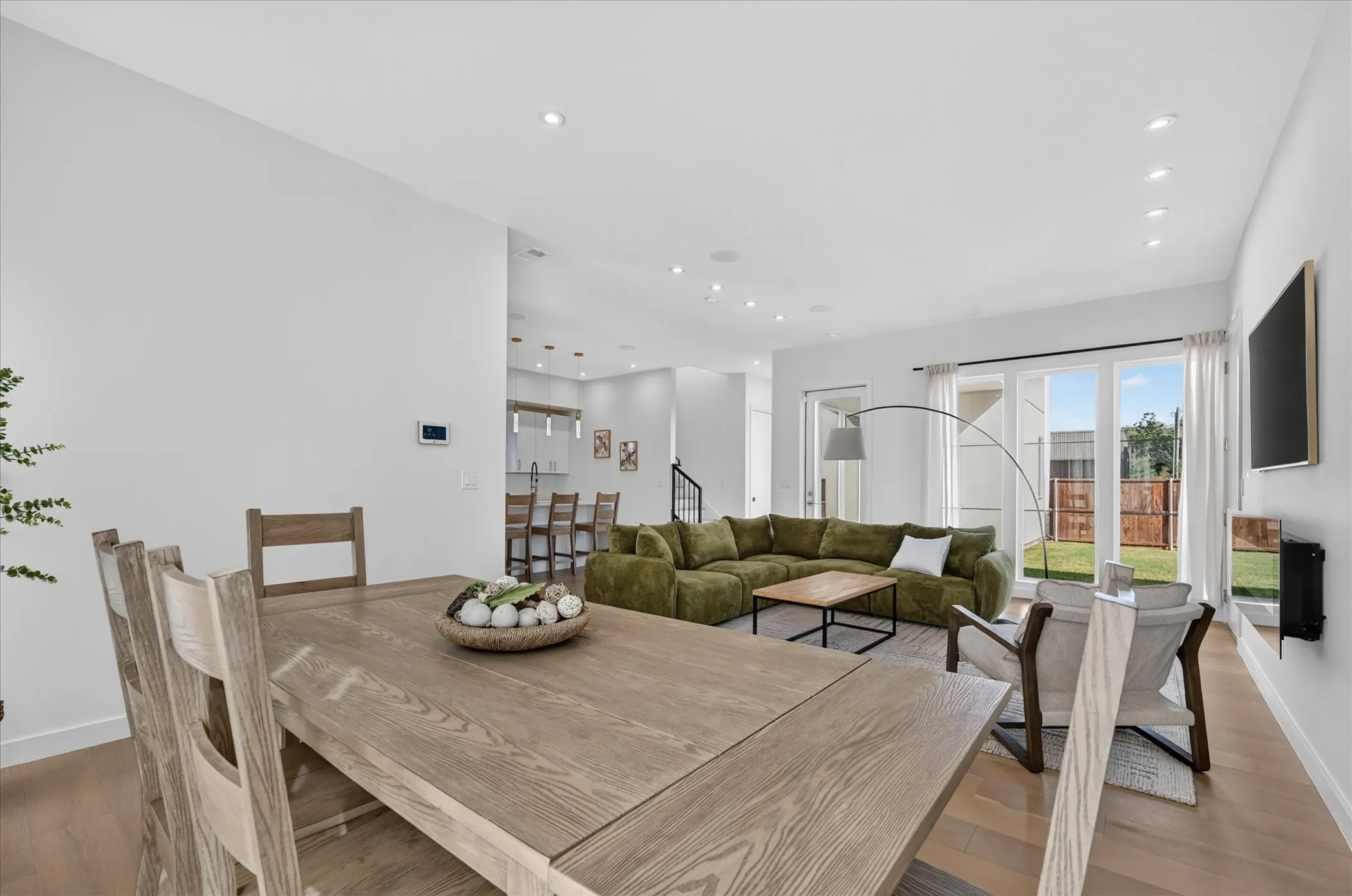 Open-concept living space featuring wood-finish flooring, recessed lighting, and expansive glass sliding doors