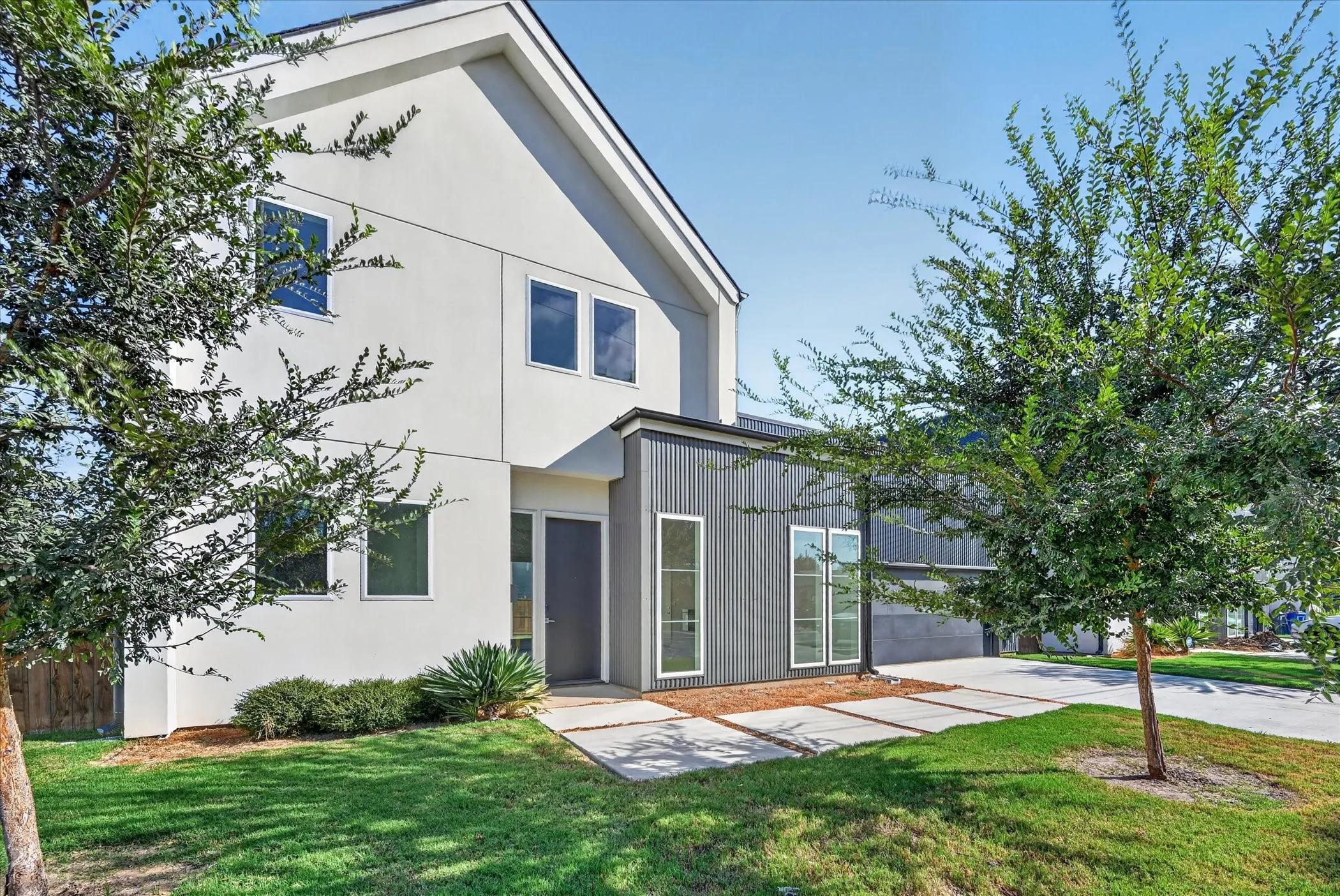 Modern exterior with white stucco and ribbed metal siding
