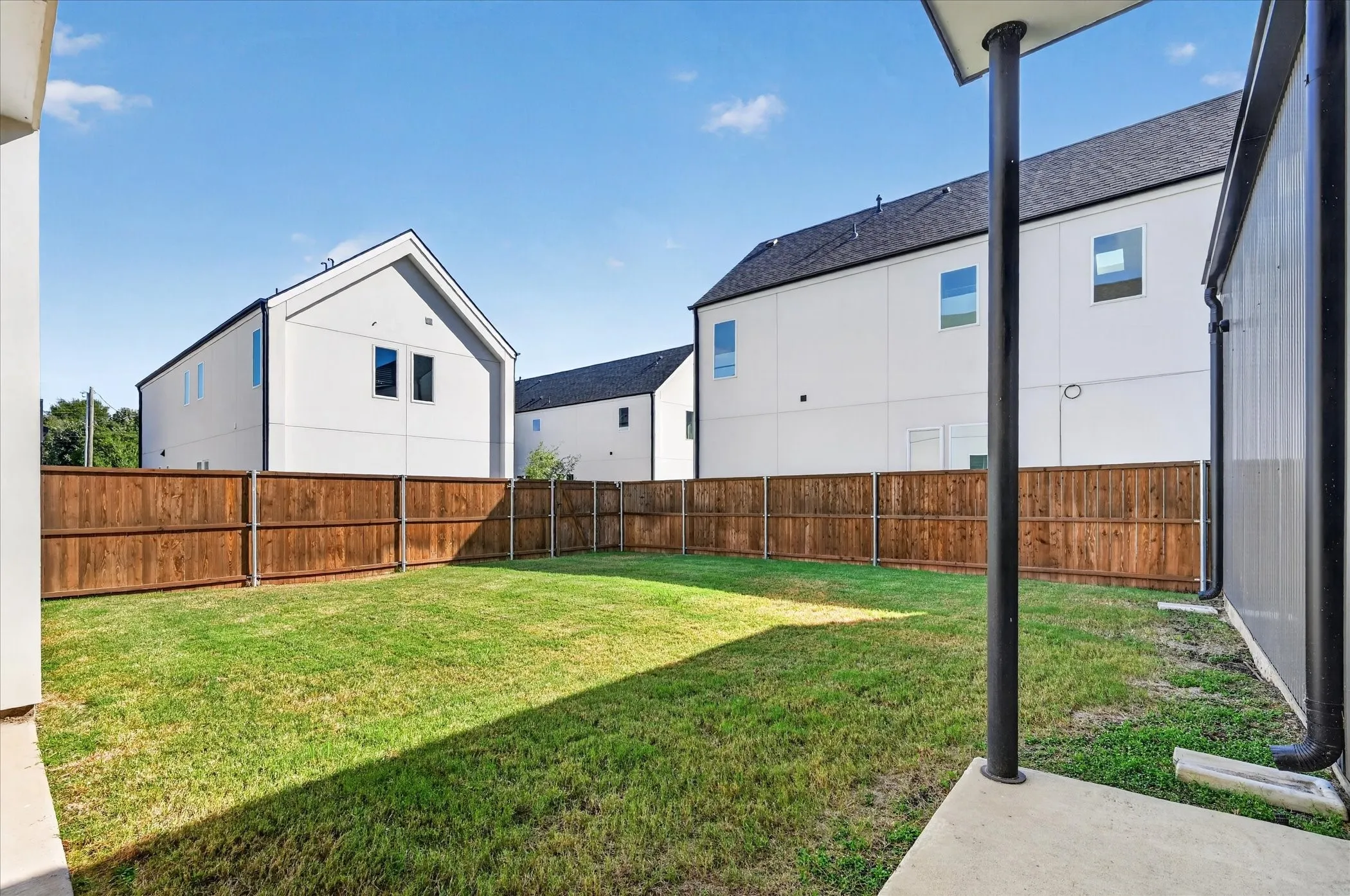 Expansive grassy yard with a privacy fence