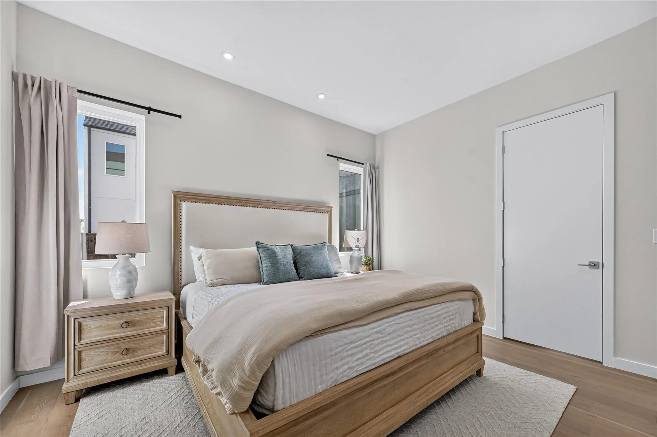 Recessed ceiling lighting, light wood-finish flooring, and white walls