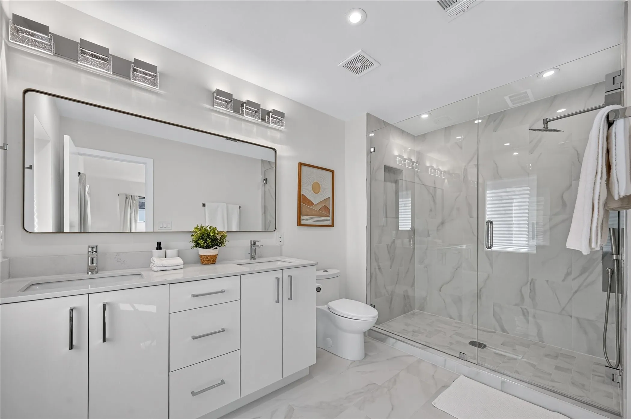 Dual vanity with white cabinetry, stone countertops, and polished chrome fixtures