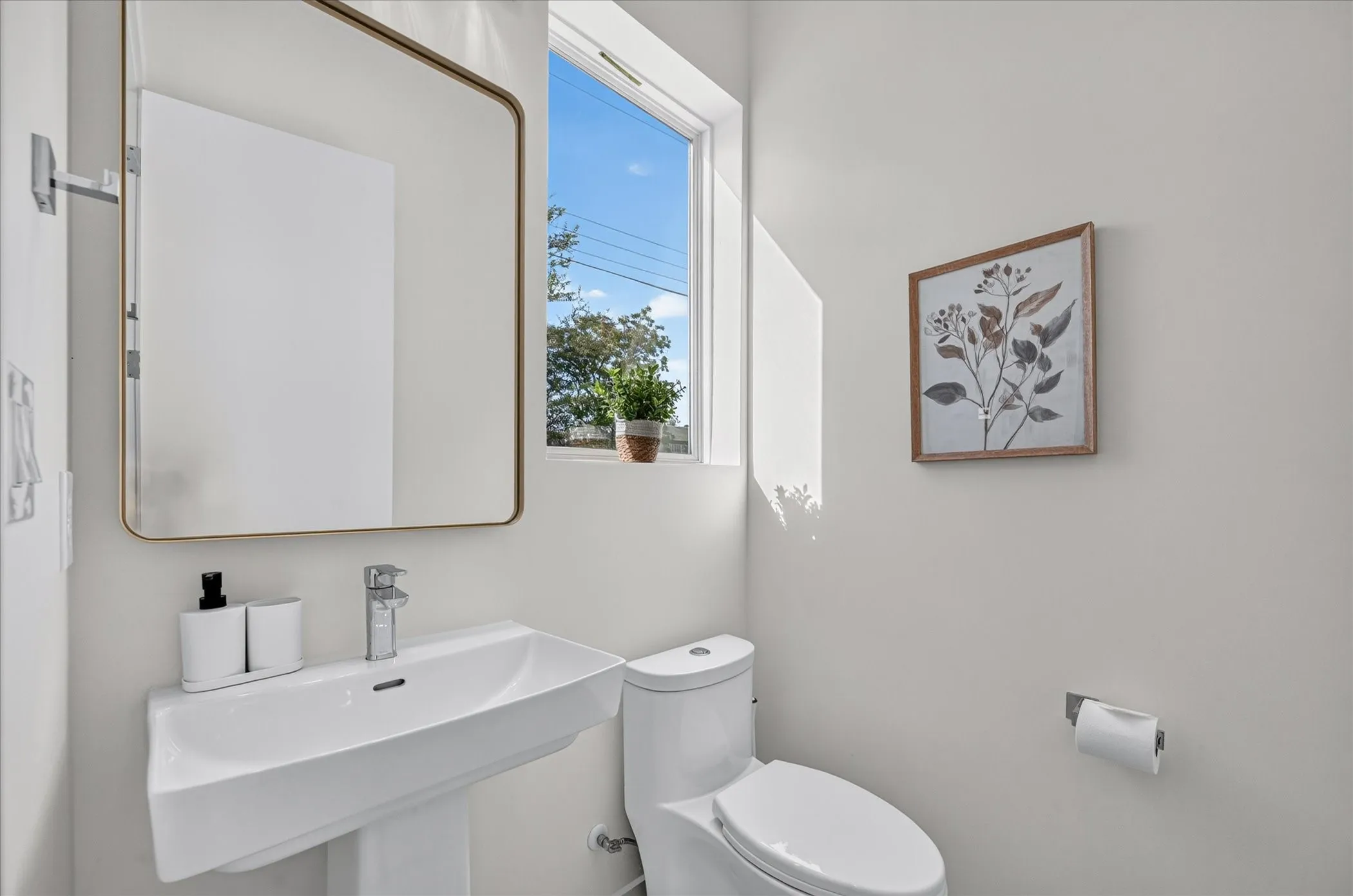 Modern powder room featuring a floating white vanity with an integrated rectangular sink, chrome wall-mounted faucet, and polished countertop