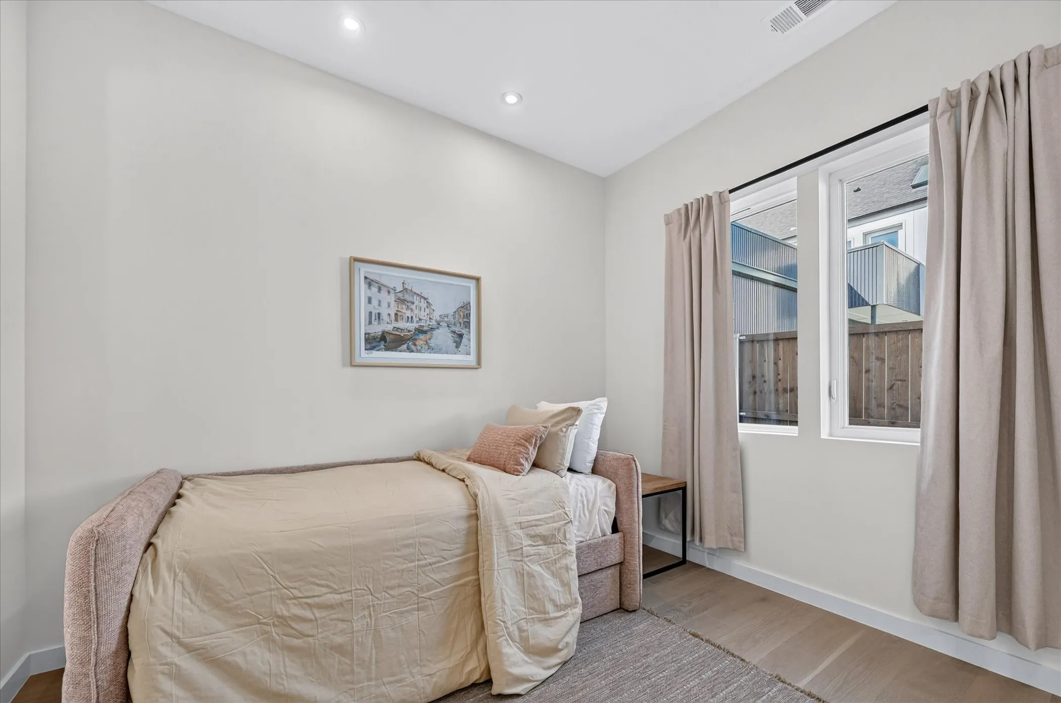 Recessed lighting, wood-finish flooring, and white walls