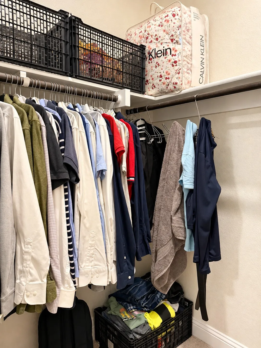 Integrated shelving system with multiple hanging rods, upper storage shelves, and neutral wall tones