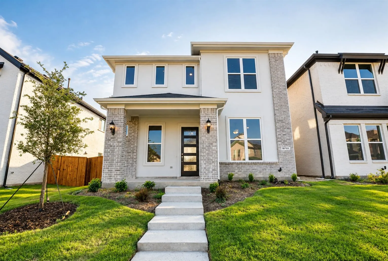 Contemporary exterior featuring light-colored stucco and brick accents