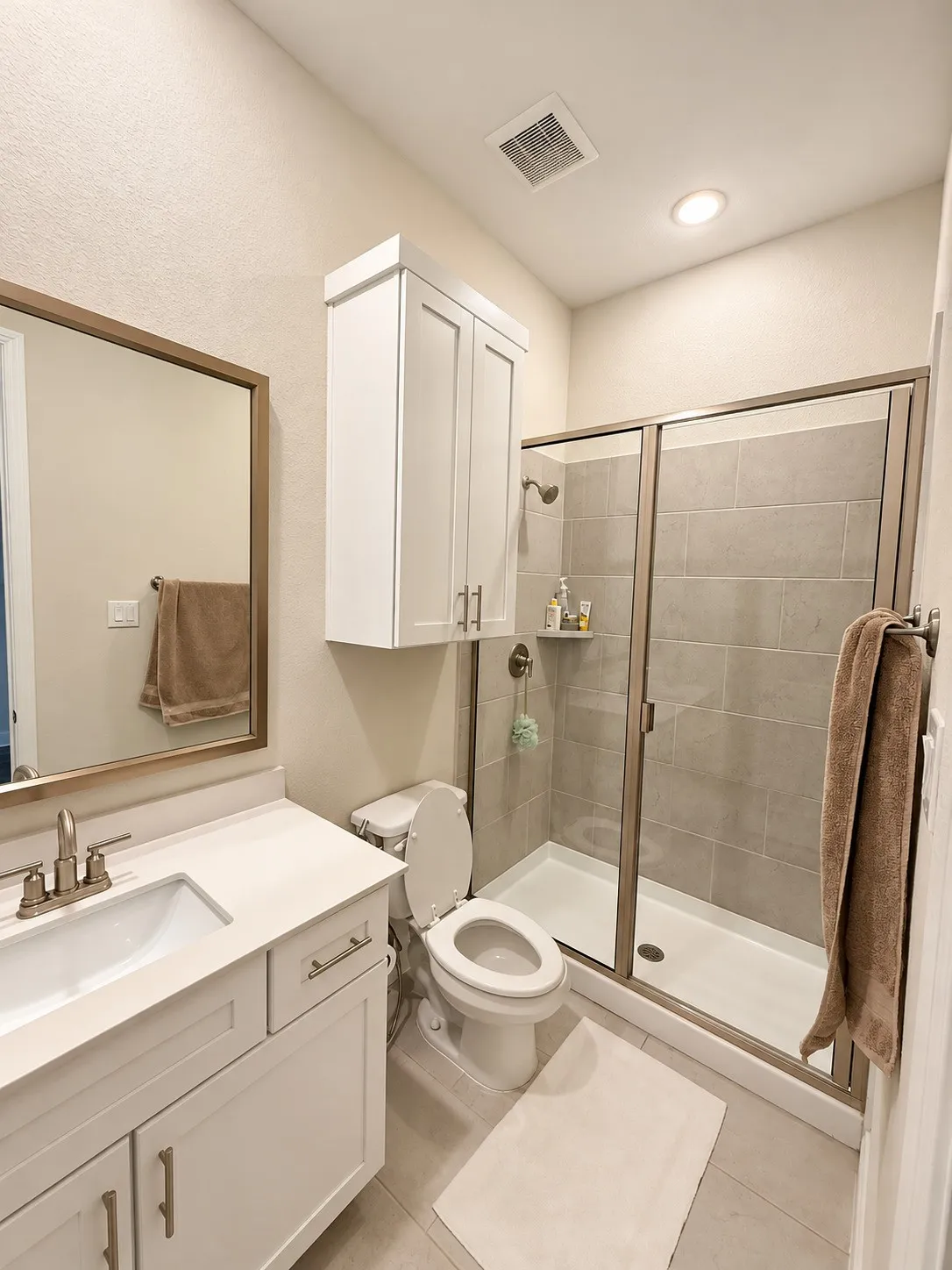 White vanity with a rectangular undermount sink, brushed nickel faucet, and a large framed mirror