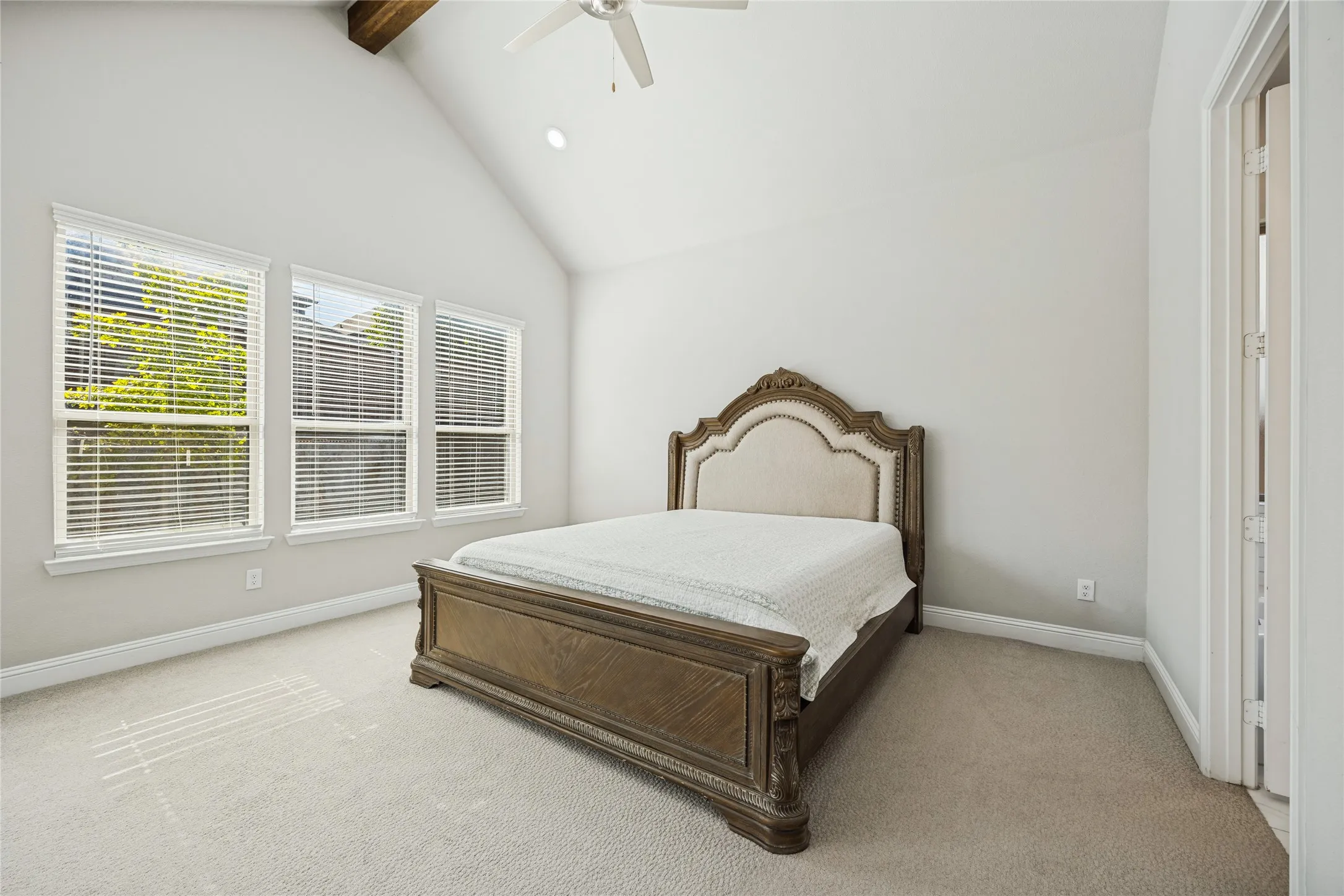 Vaulted ceiling with exposed wood beam, recessed lighting, and ceiling fan