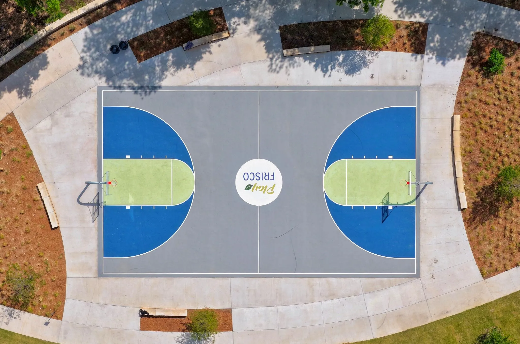 Multi-color basketball court featuring a light gray, blue, and lime green surface
