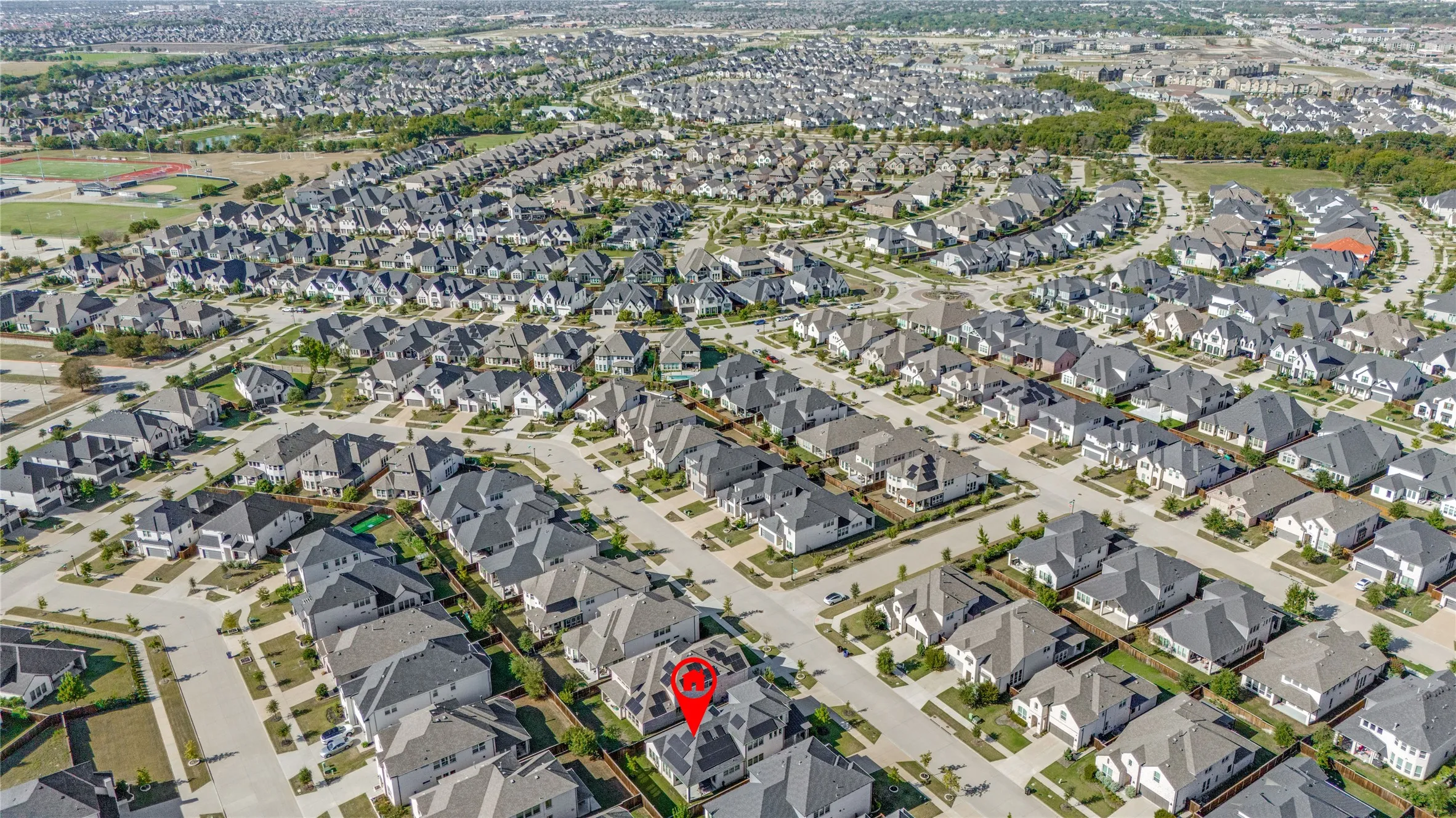 Expansive residential development featuring numerous single-story and two-story homes with dark-toned roofing and light-colored exteriors