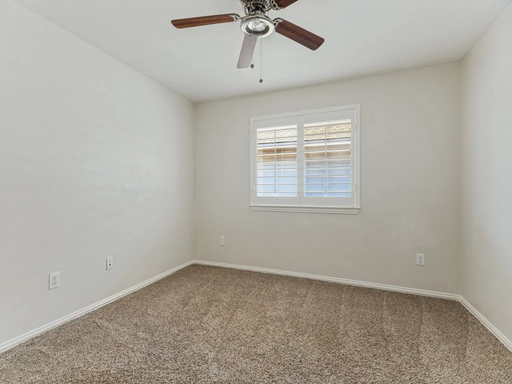 Textured walls with a window featuring white plantation shutters