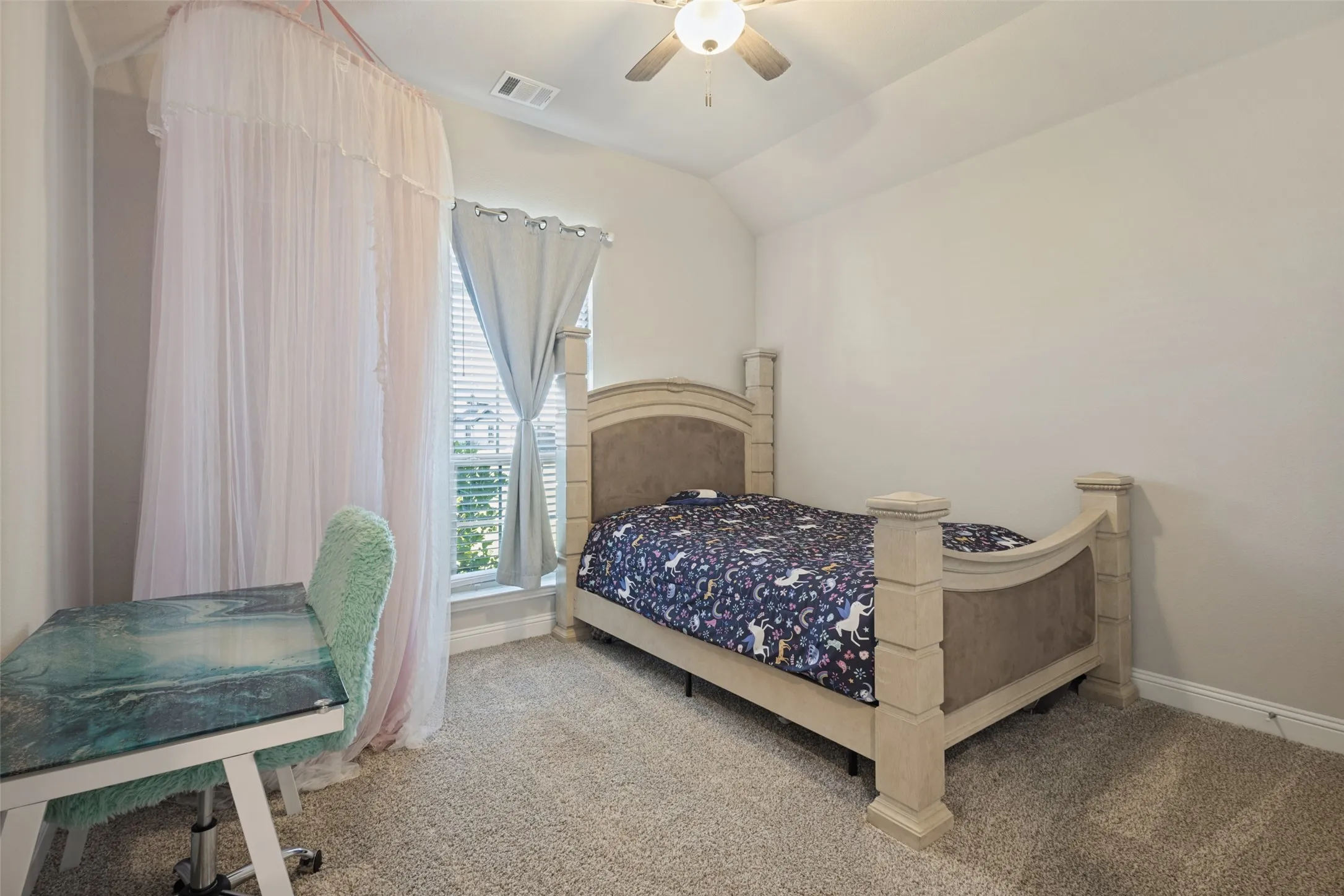 Carpeted room with a vaulted ceiling, a window featuring blinds, and a ceiling fan with integrated lighting
