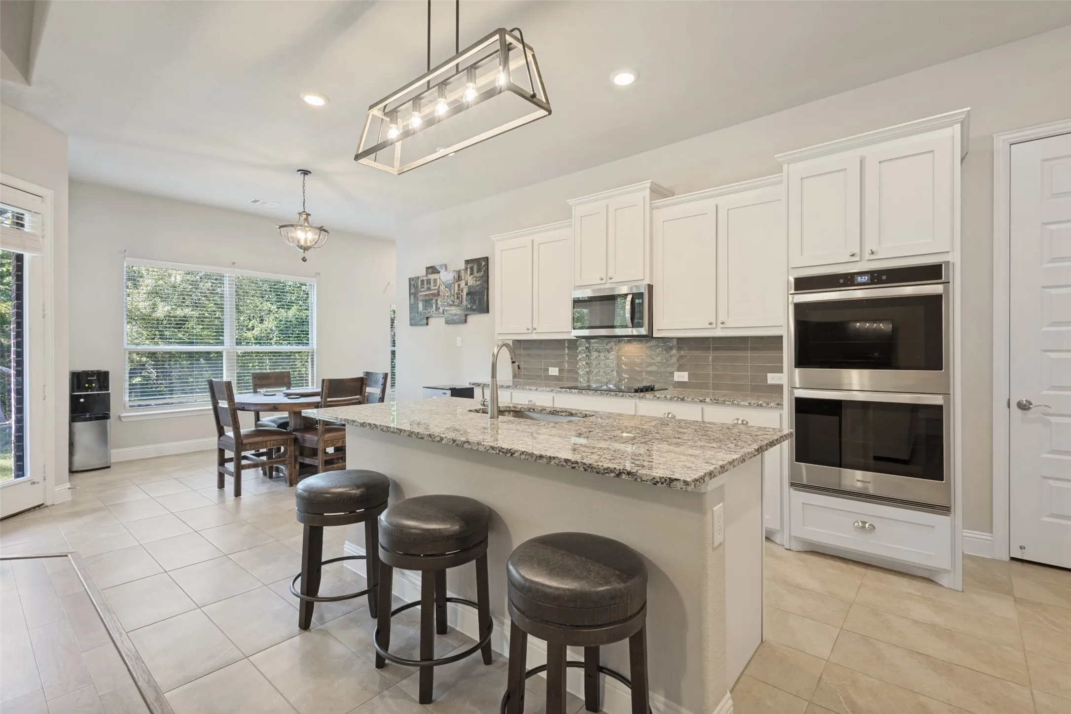 Kitchen featuring a central island with countertop, white cabinetry, stainless steel appliances, and tile flooring