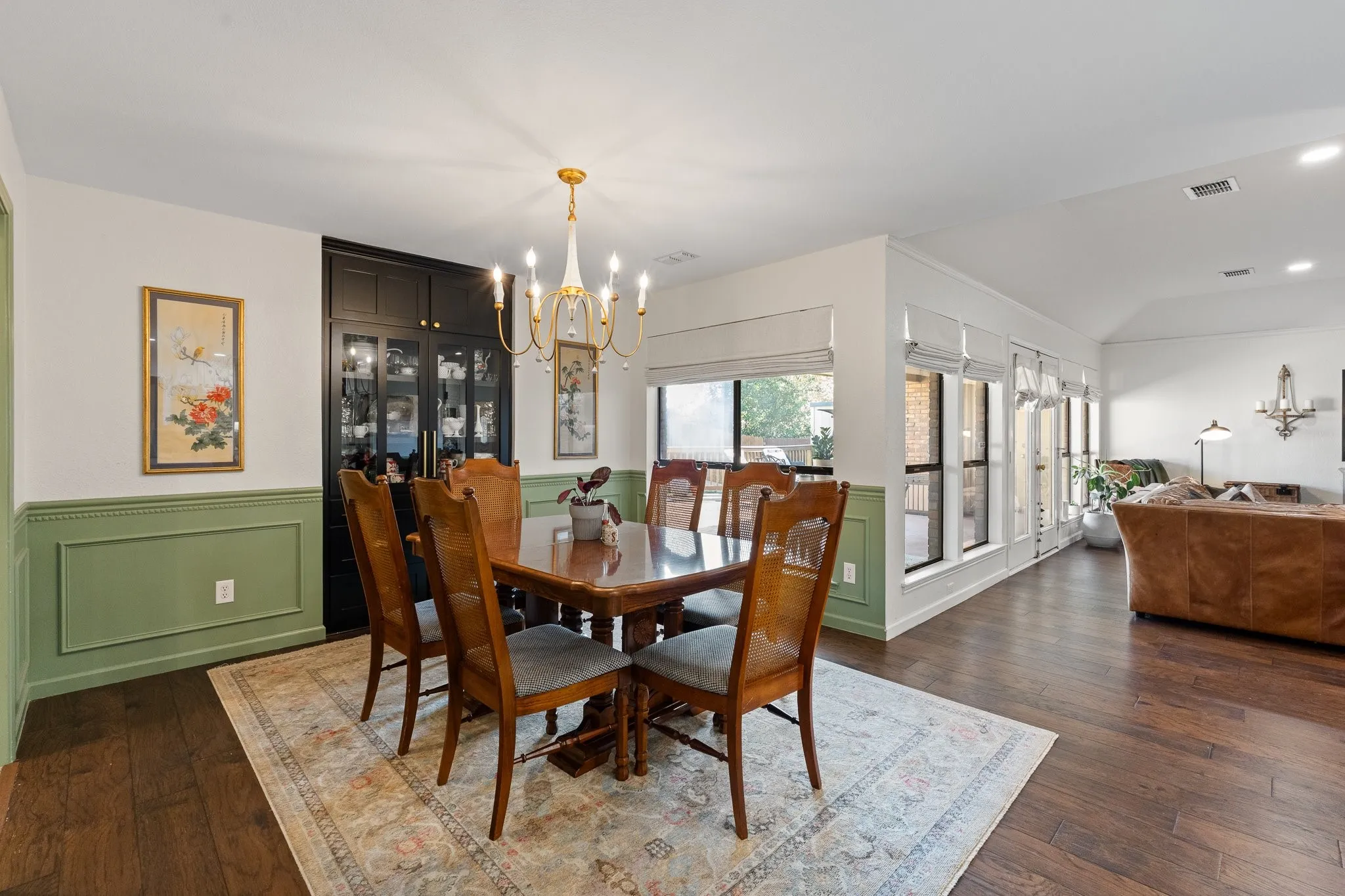 Wood flooring complemented by wainscoting and a built-in cabinet