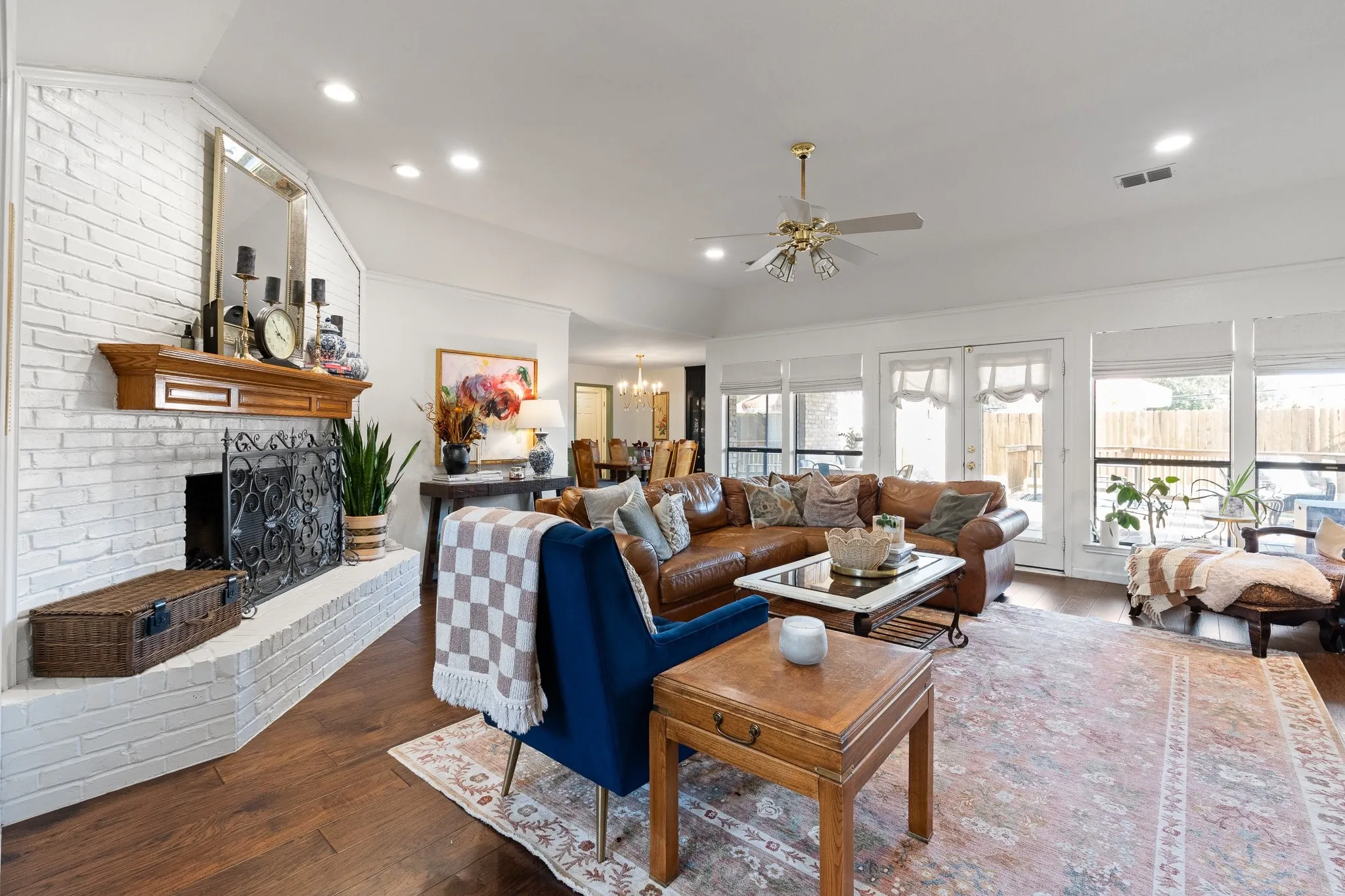 Wood flooring throughout, complemented by a white brick fireplace with a wood mantle