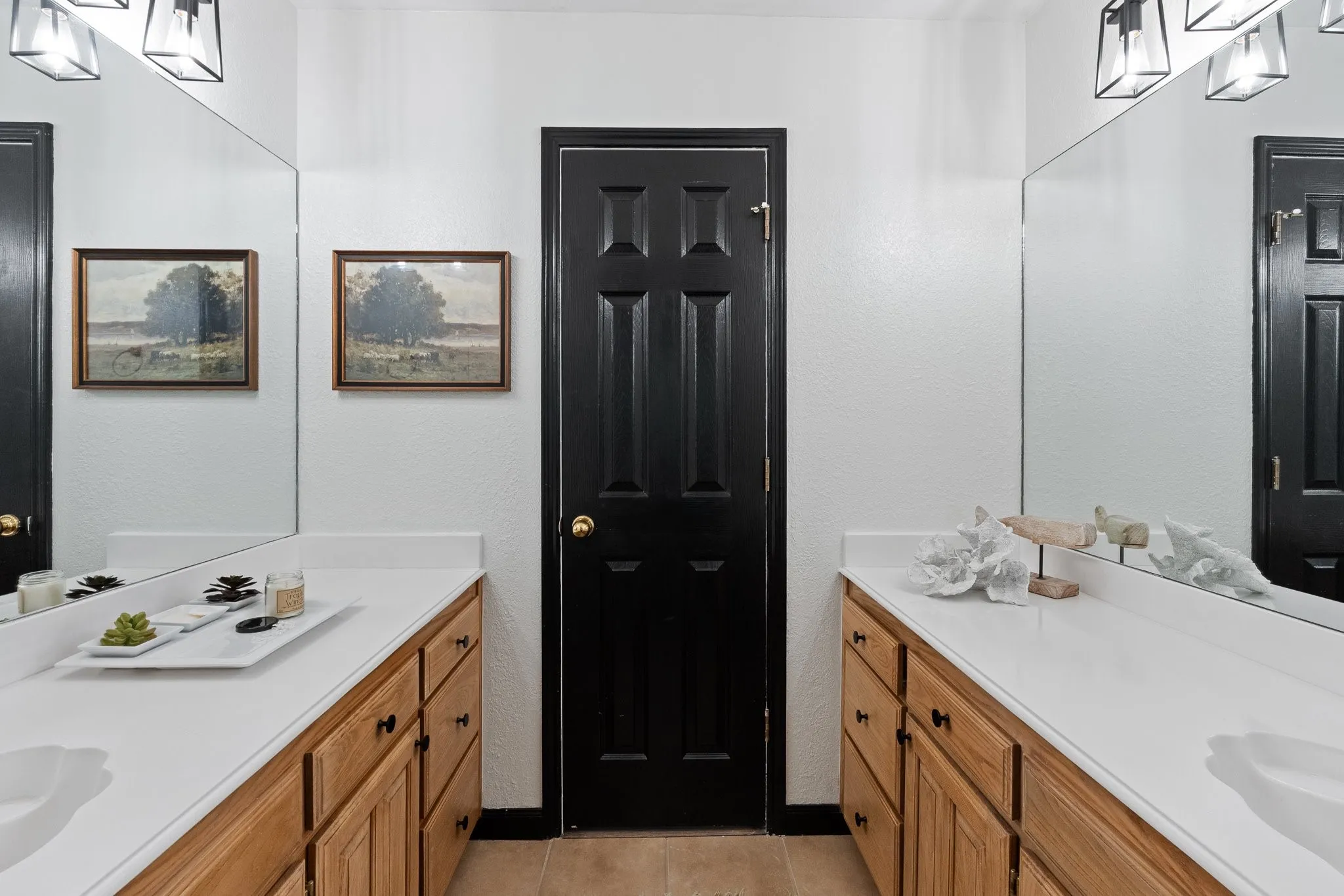 Dual vanity with white countertops and wood-finish cabinetry