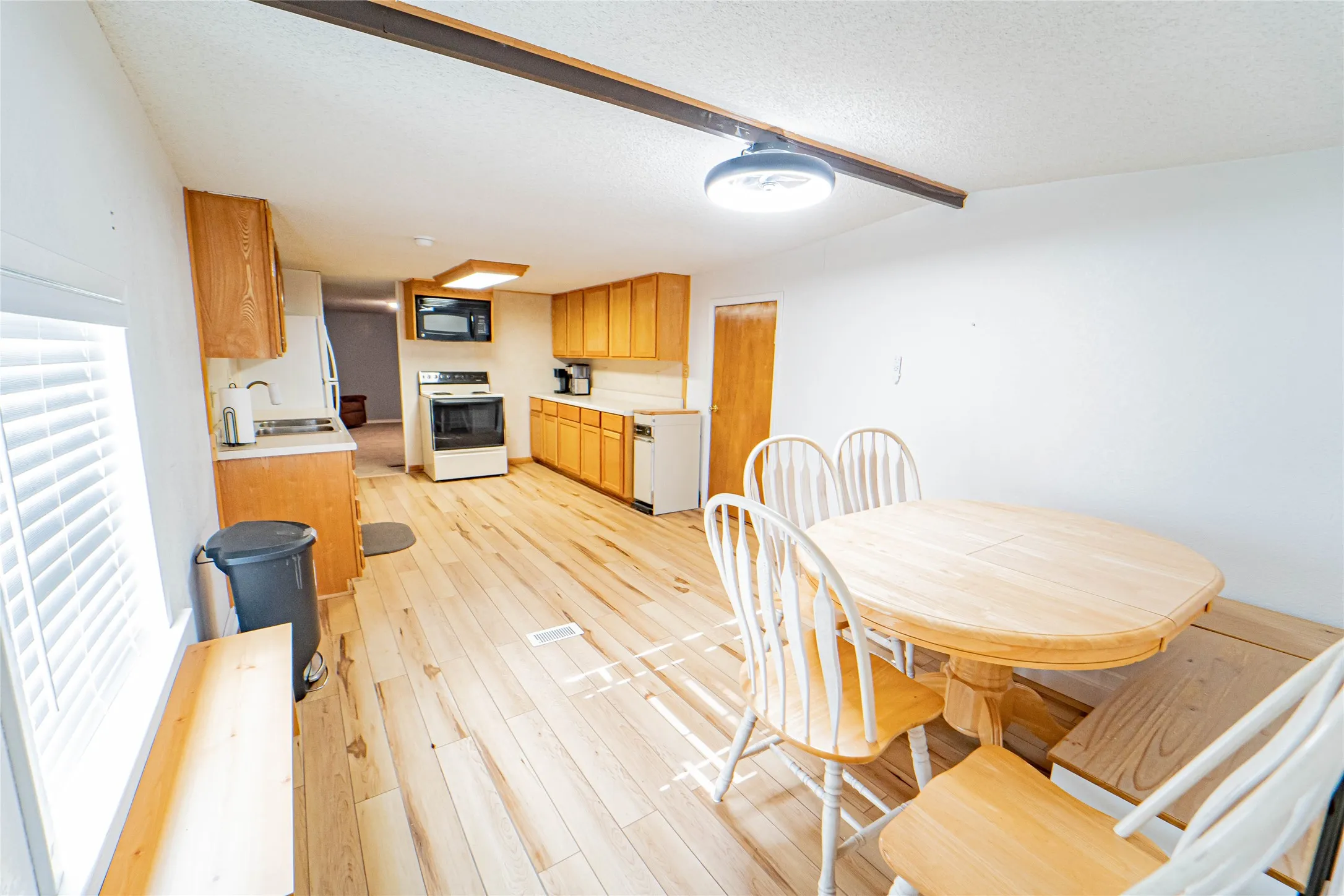 Wood-finish flooring, recessed lighting, and wood cabinetry with laminate countertops