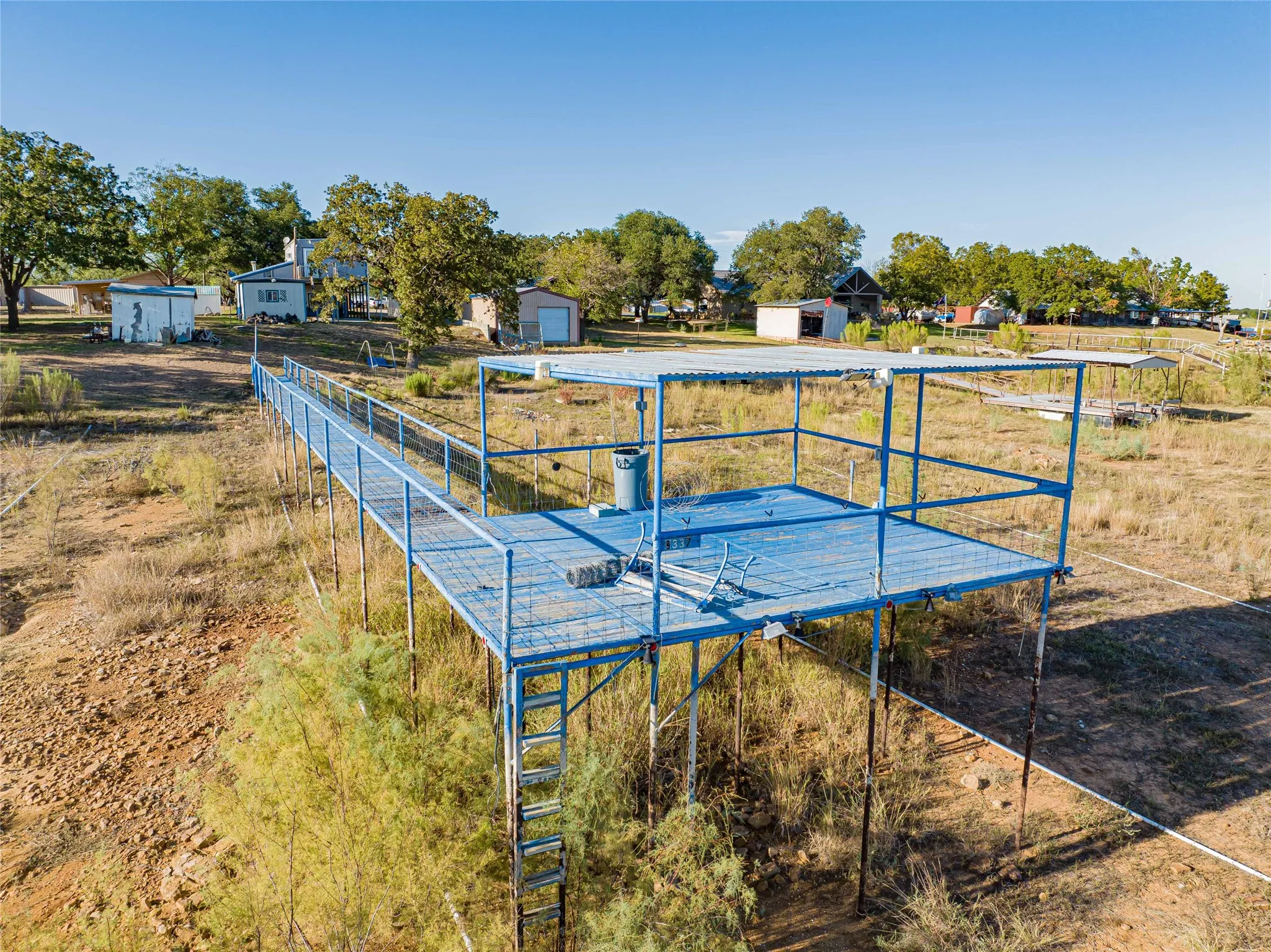 Elevated metal deck with a covered area, accessed by a metal walkway and an attached ladder