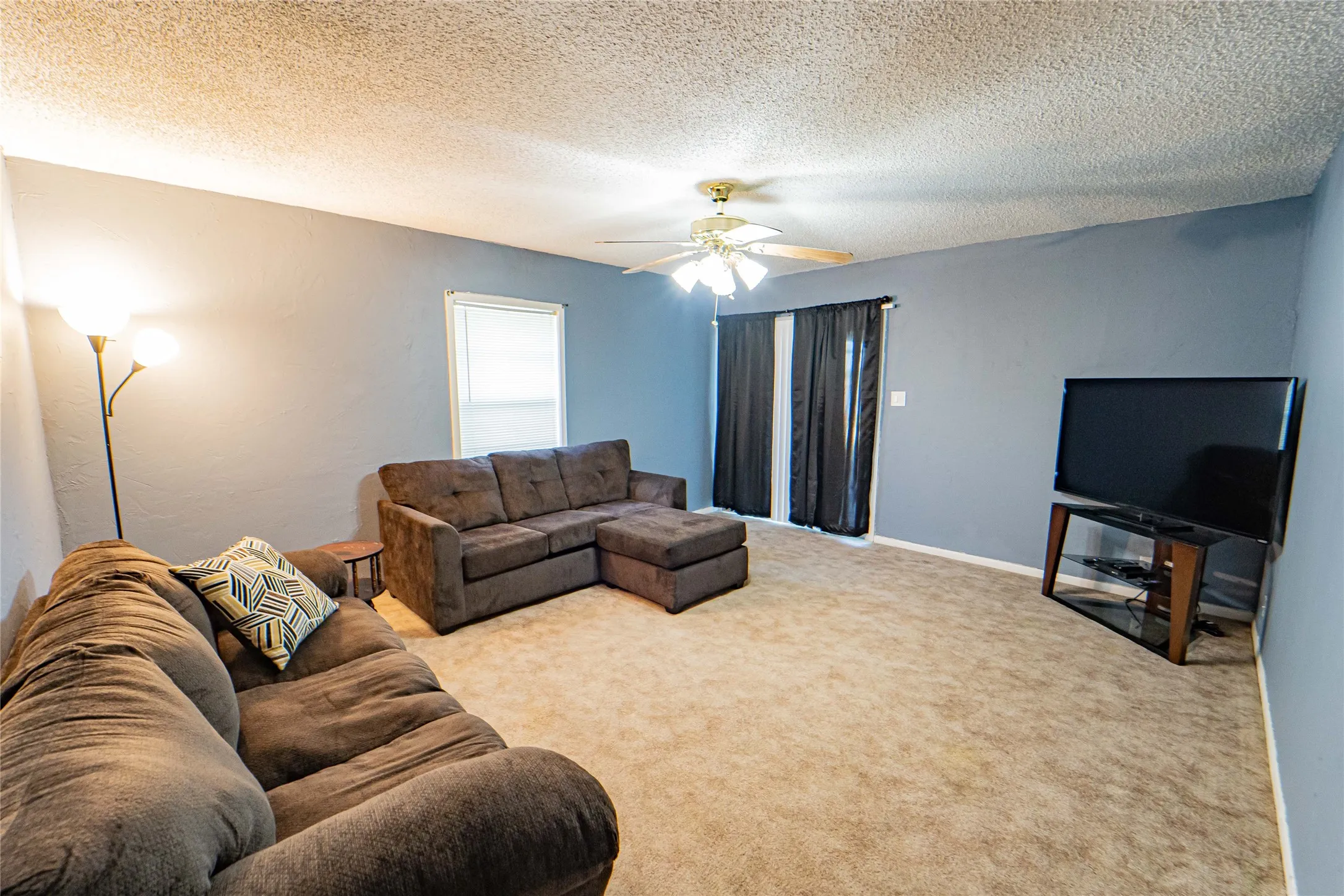 Carpeted flooring, ceiling fan, and sliding glass door