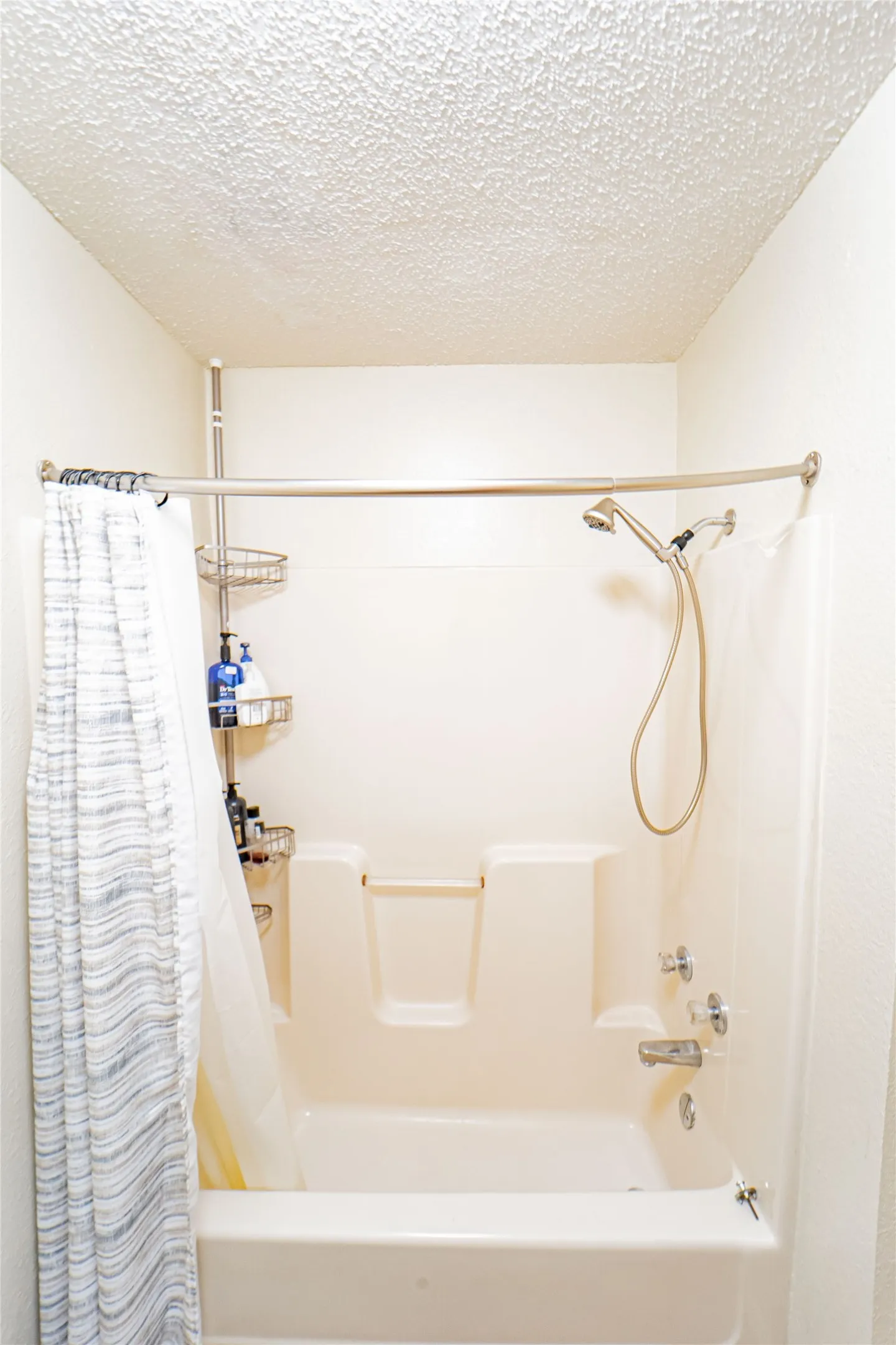 Bathtub-shower combination with a textured ceiling