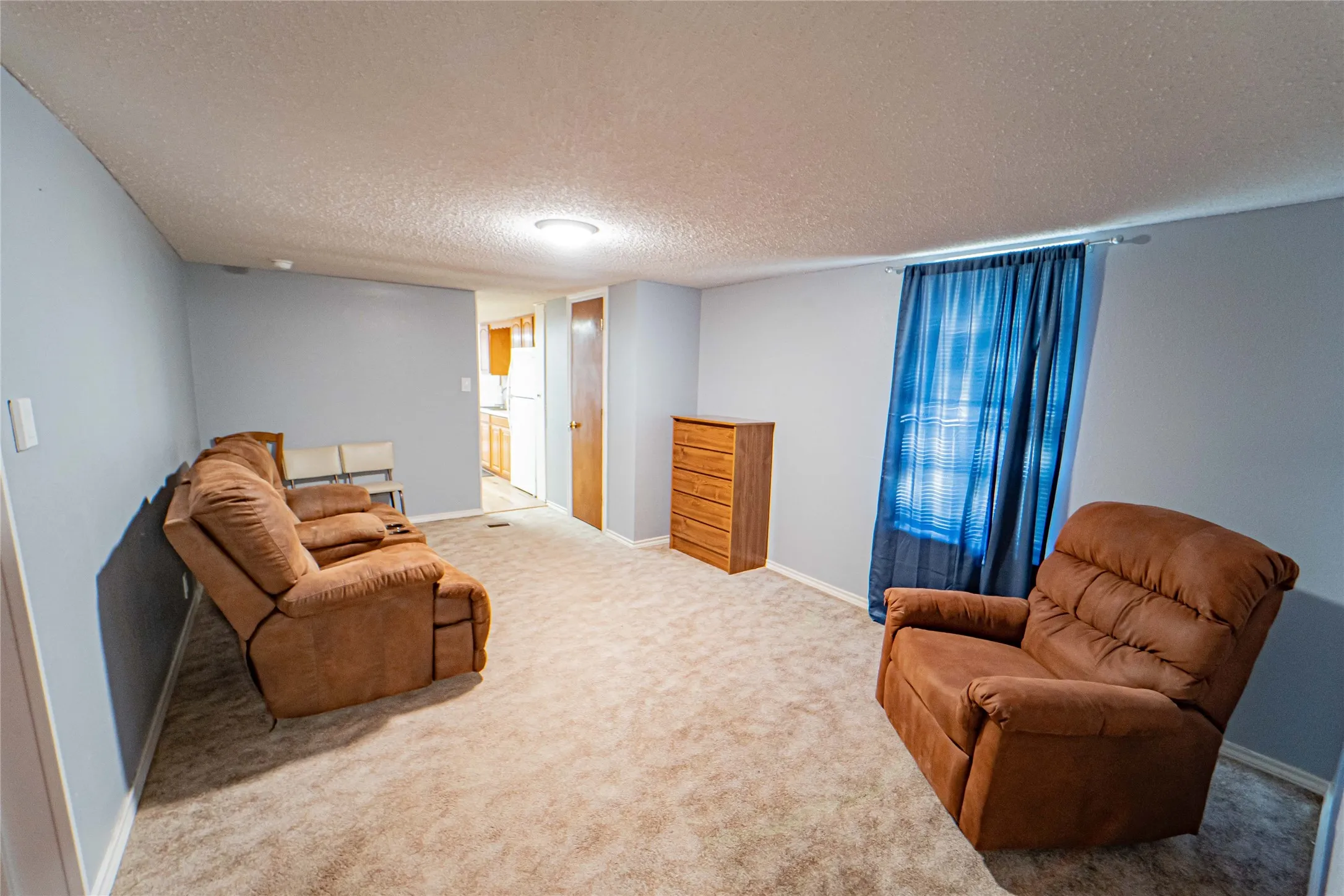 Neutral wall color, carpeted flooring, and an overhead light fixture